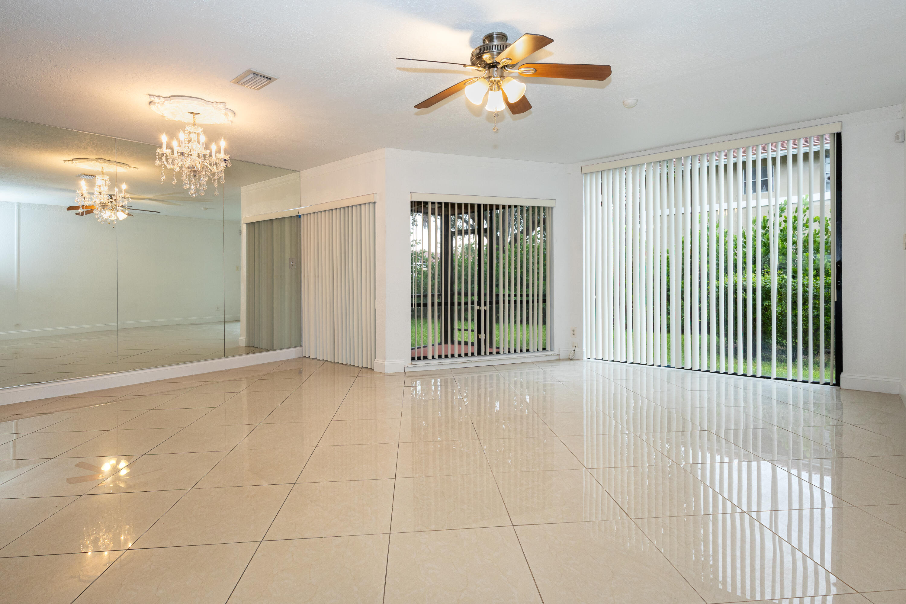 Spacious open-concept room showcasing polished tile flooring, recessed ceiling lighting, and a ceiling fan with brushed metal finish Spacious open-concept room showcasing polished tile flooring, recessed ceiling lighting, and a ceiling fan with brushed metal finish
