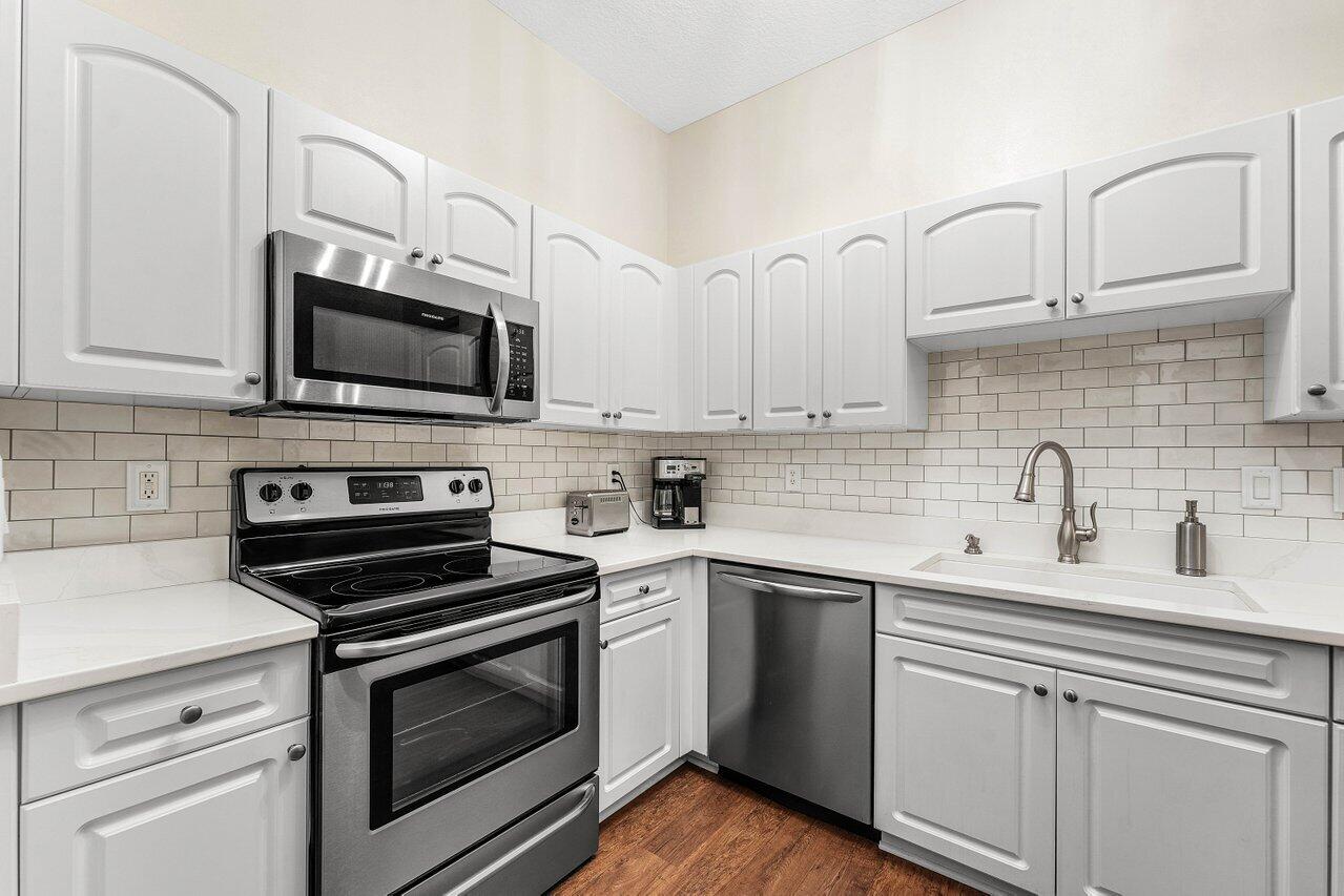 Quartz countertops, Frigidaire Gallery appliances, modern backsplash...