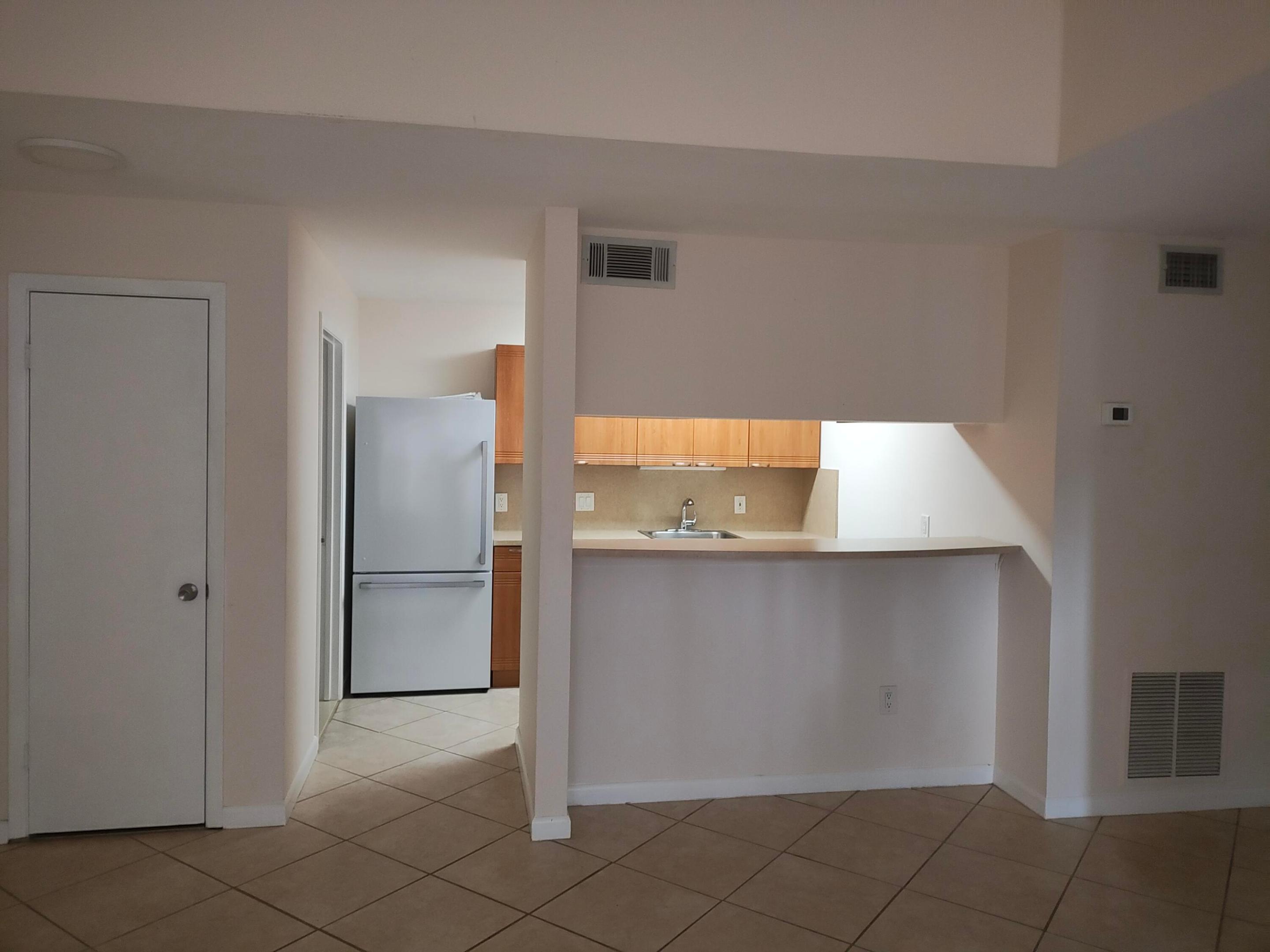 View from living room to kitchen with bar stool height counter area View from living room to kitchen with bar stool height counter area