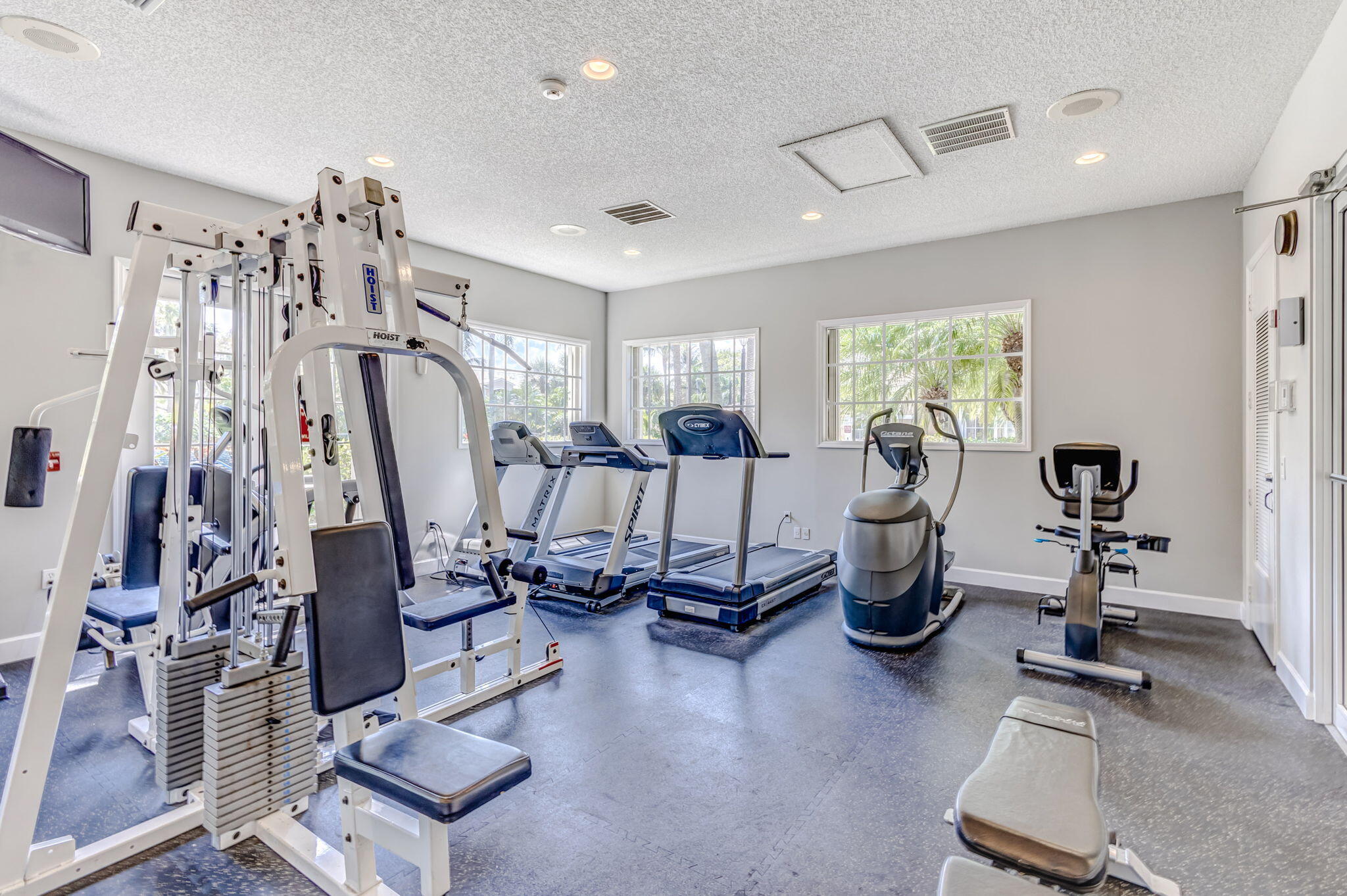 Fitness center featuring rubber flooring, recessed lighting, and multiple windows
