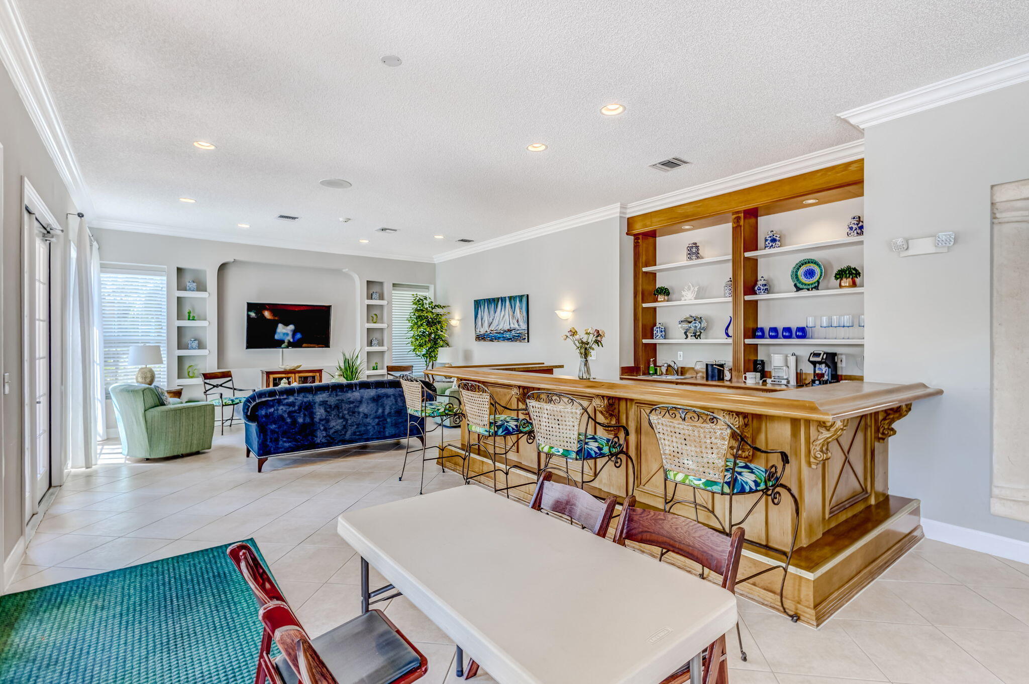 Custom built-in wood bar with integrated shelving and countertop, recessed lighting, tile flooring, and arched architectural niches