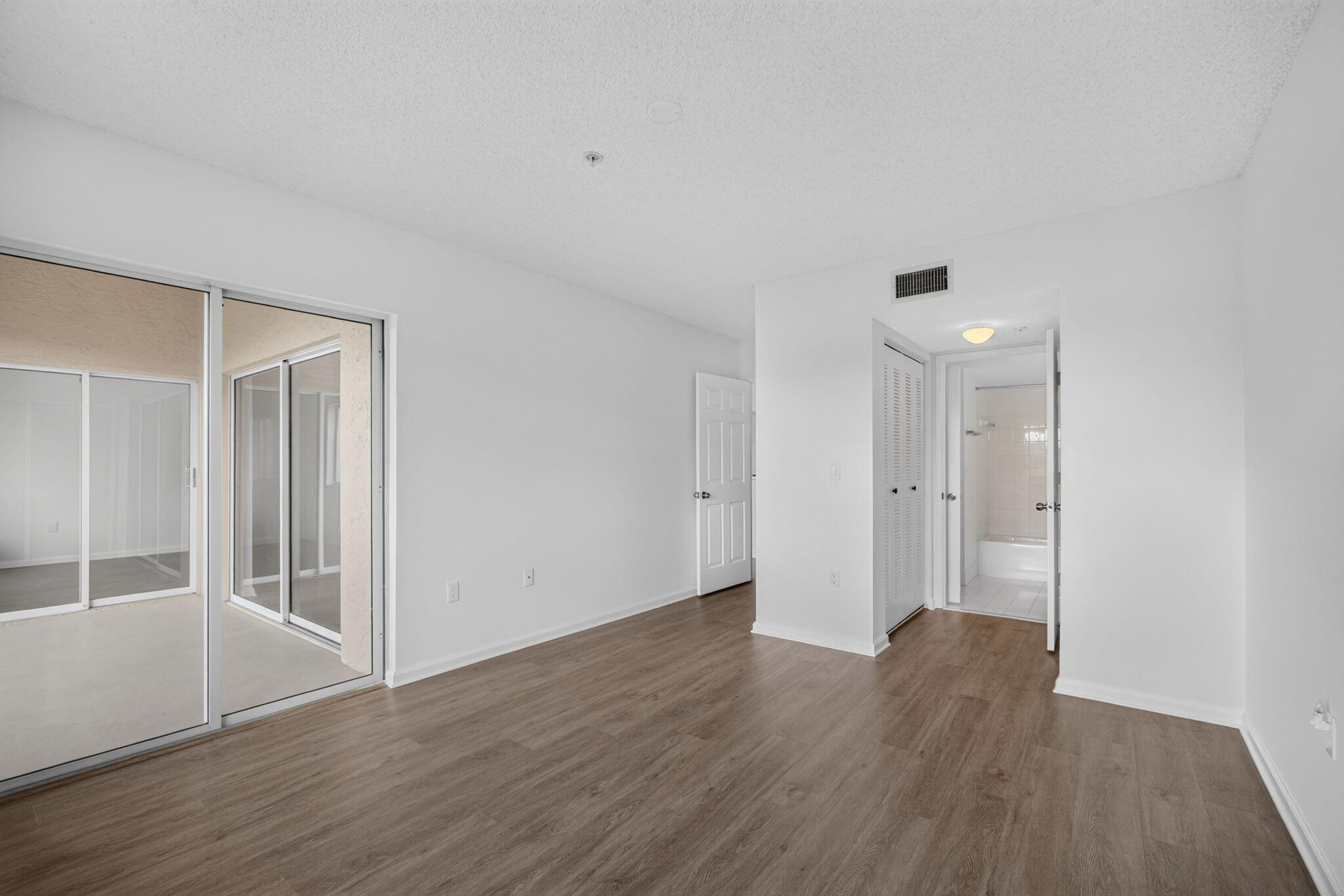 Vinyl Plank flooring, sliding glass patio door, and bi-fold closet doors