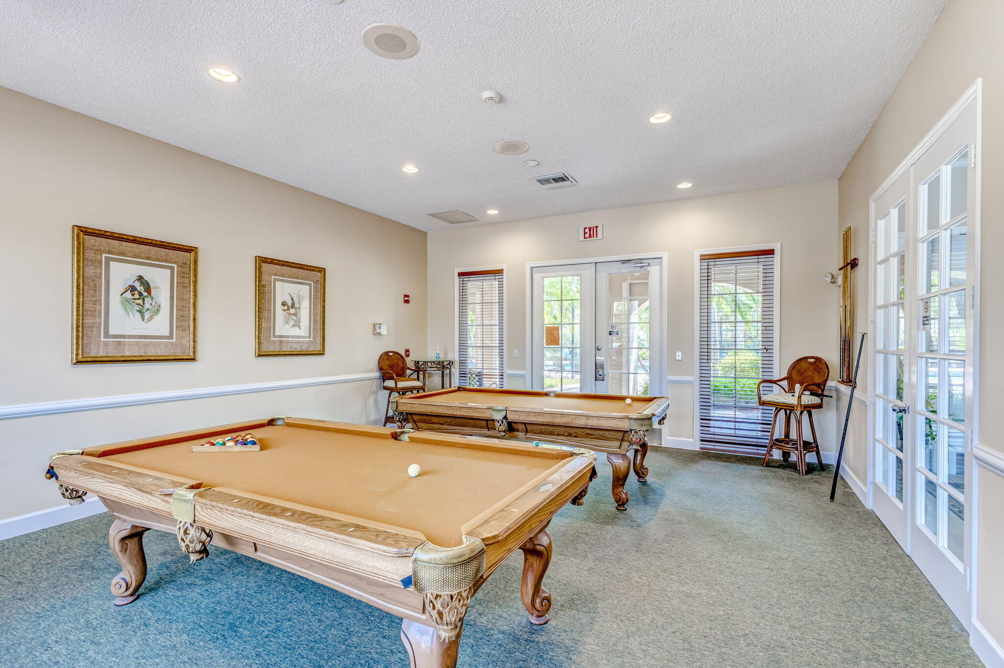 Recreation room featuring recessed lighting, chair rail molding, and multiple glass-paneled entry doors