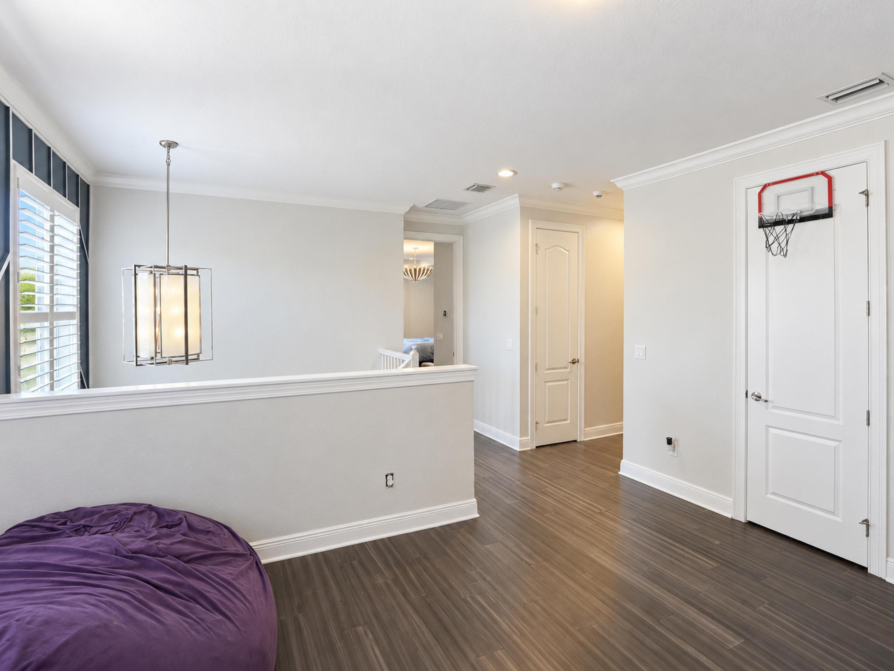 Wood-finish flooring, crown molding, multi-panel doors, and a decorative pendant light fixture