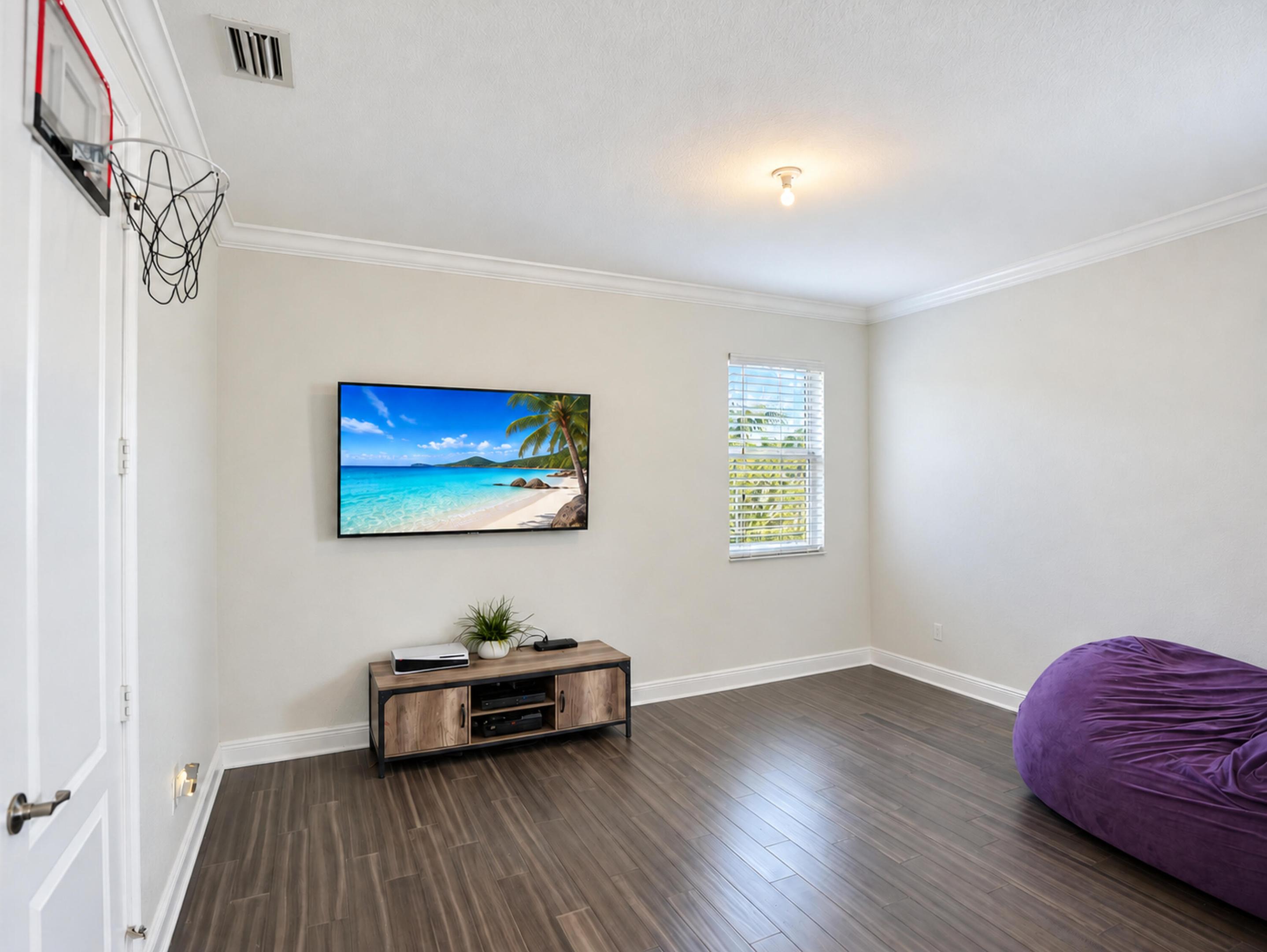Room featuring wood-finish flooring, crown molding, and a single-pane window with white horizontal blinds