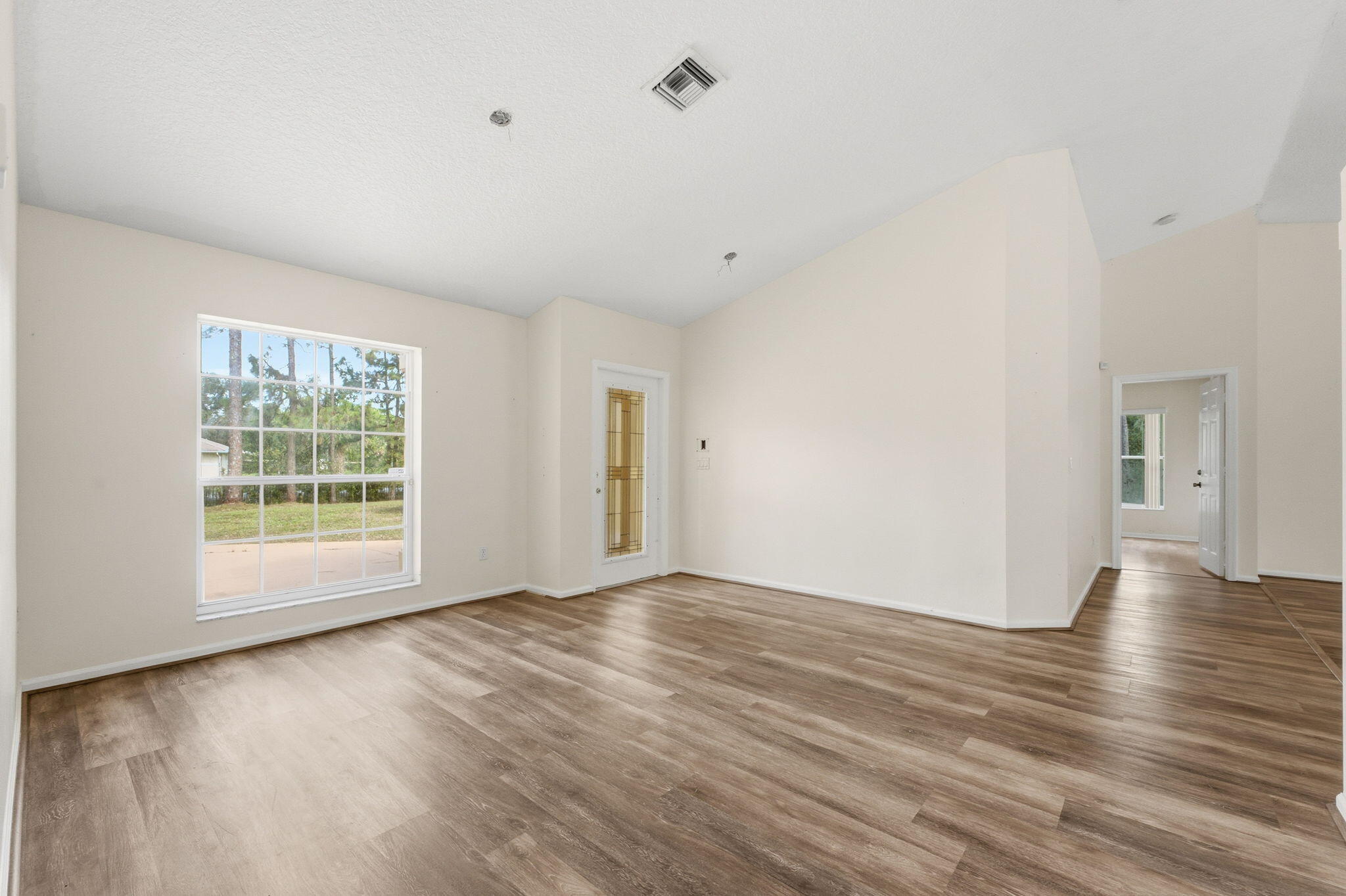 Vaulted ceilings, wood-finish flooring, and a single-hung window with a muntin grid