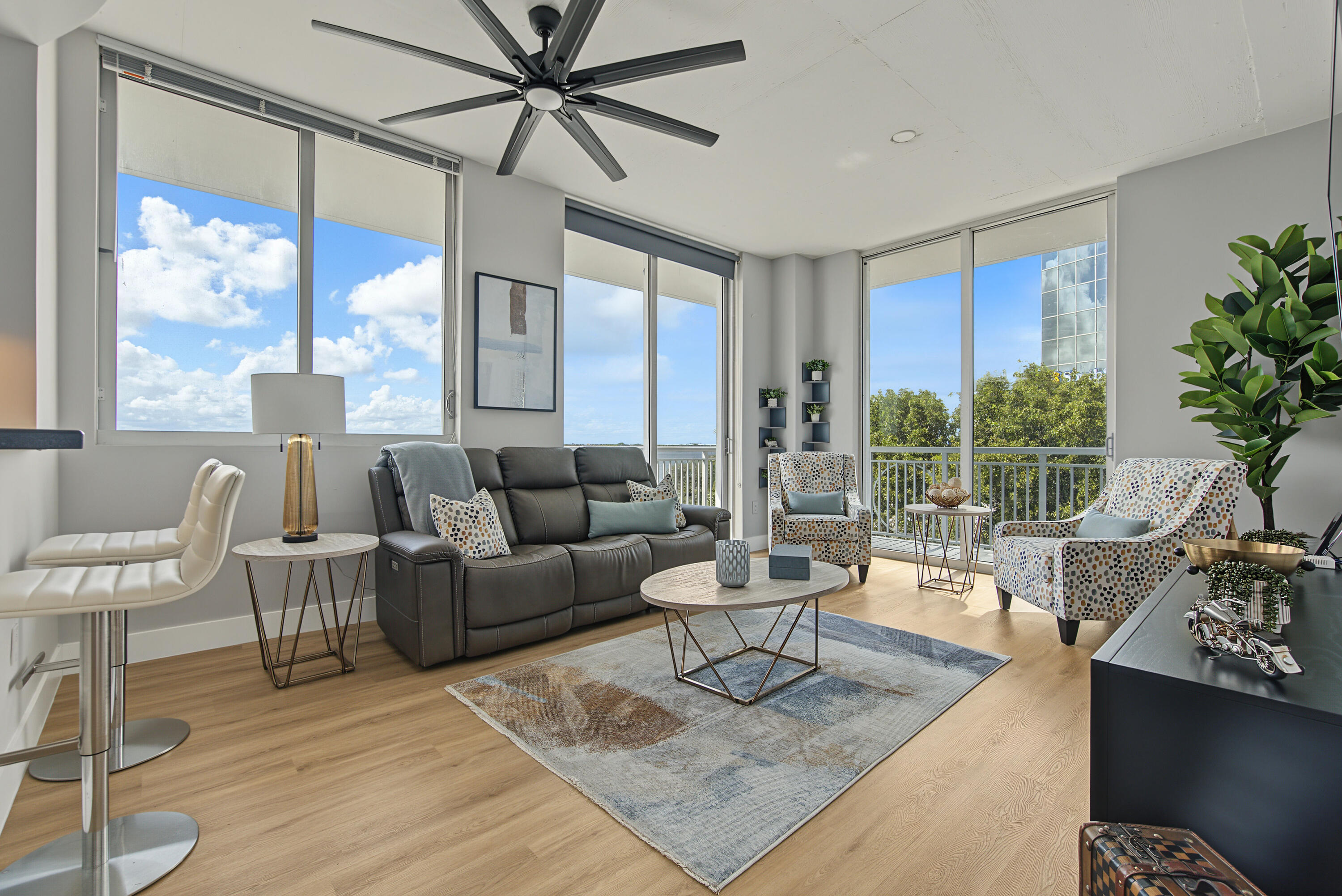 relaxing living room surrounded by large windows and wrap-around balcony.