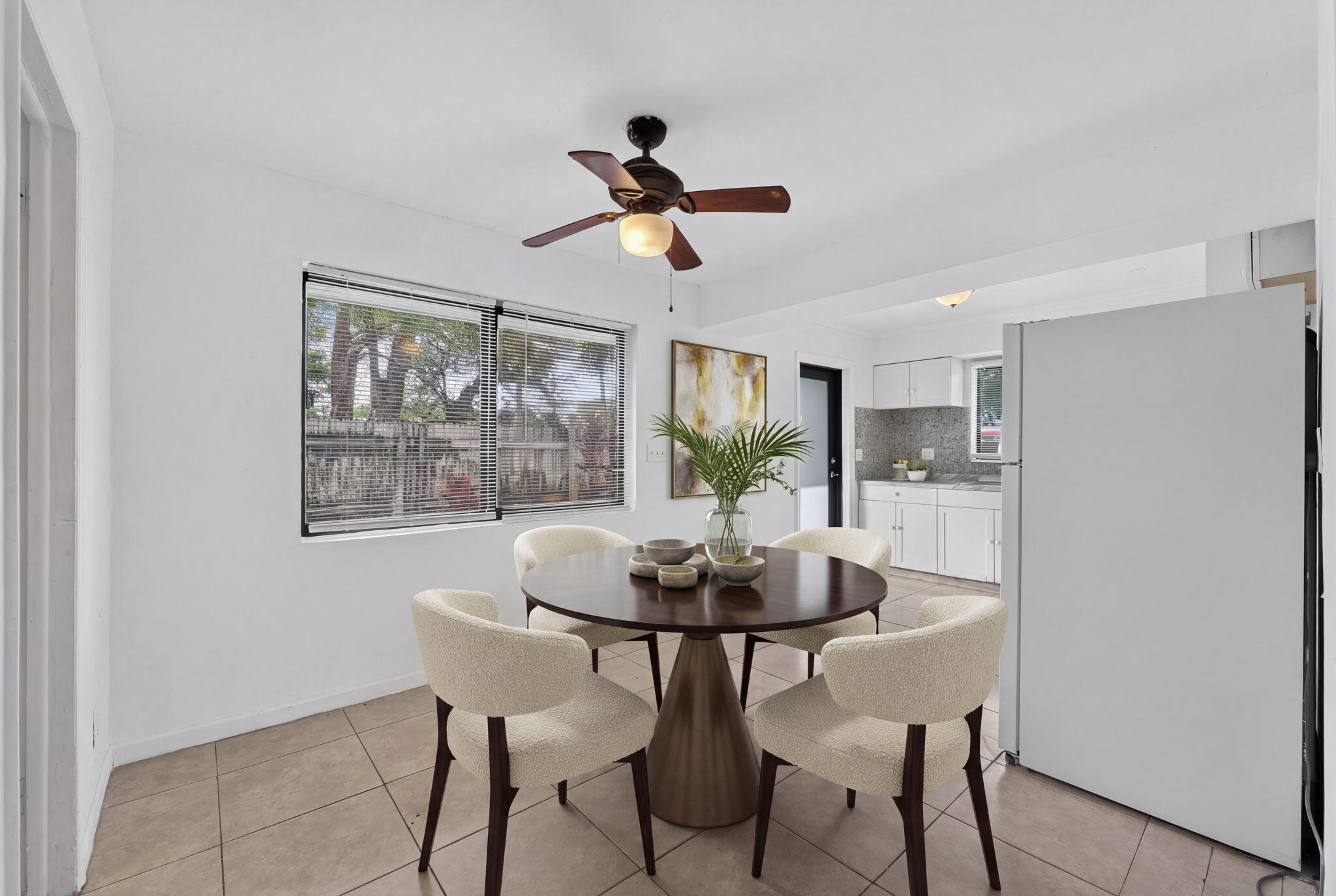 Tile flooring, dual-pane window, ceiling fan with light fixture, and white cabinetry