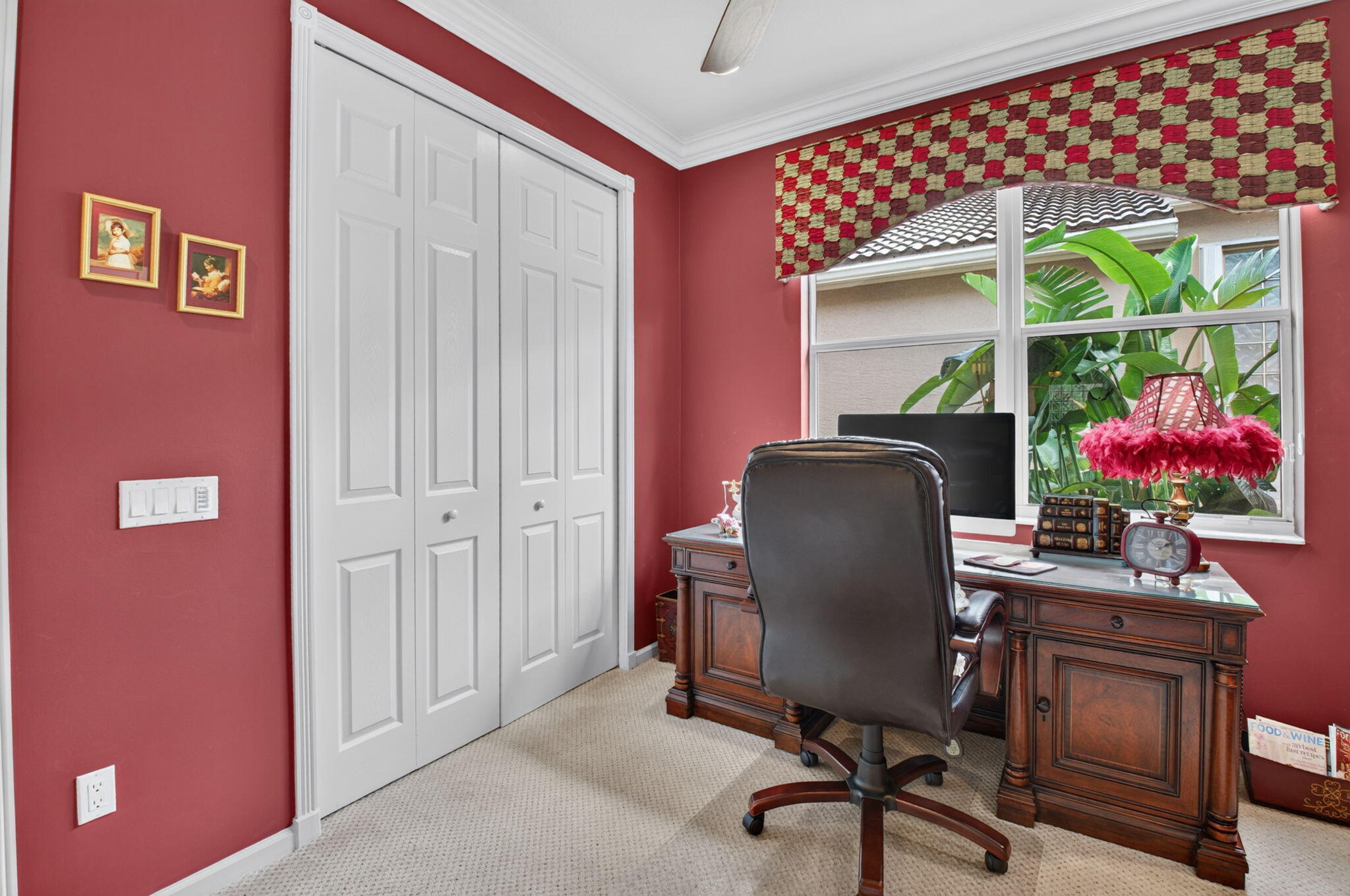 Bifold closet doors with a six-panel design, neutral-toned carpeting, crown molding, and a single-hung window featuring white trim
