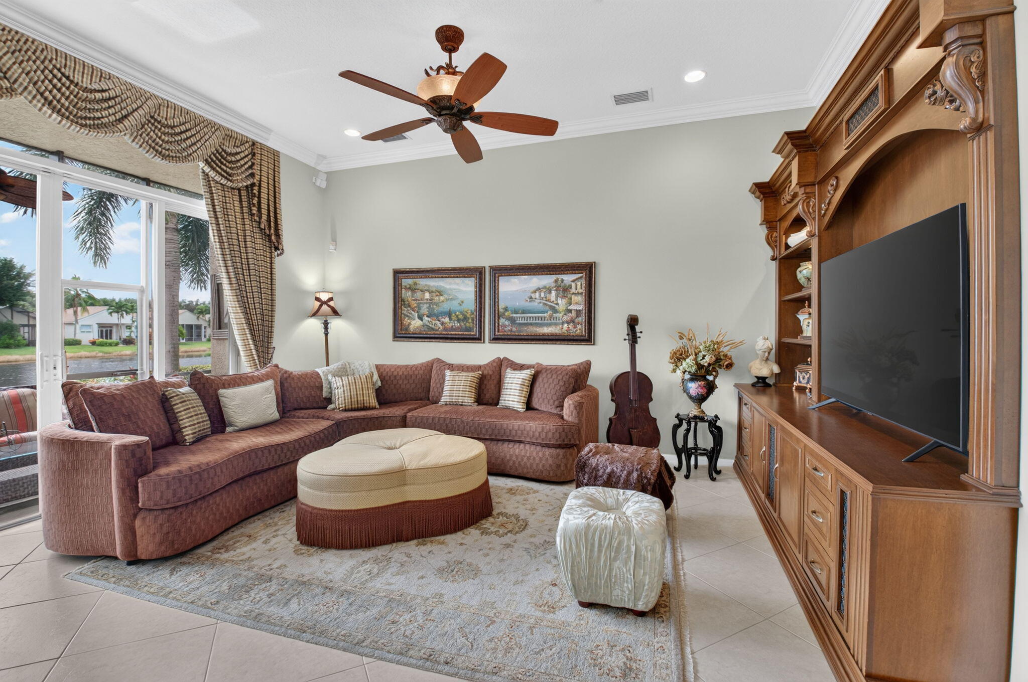 Living area featuring ceramic tile flooring, built-in wooden cabinetry, recessed lighting, and a ceiling fan