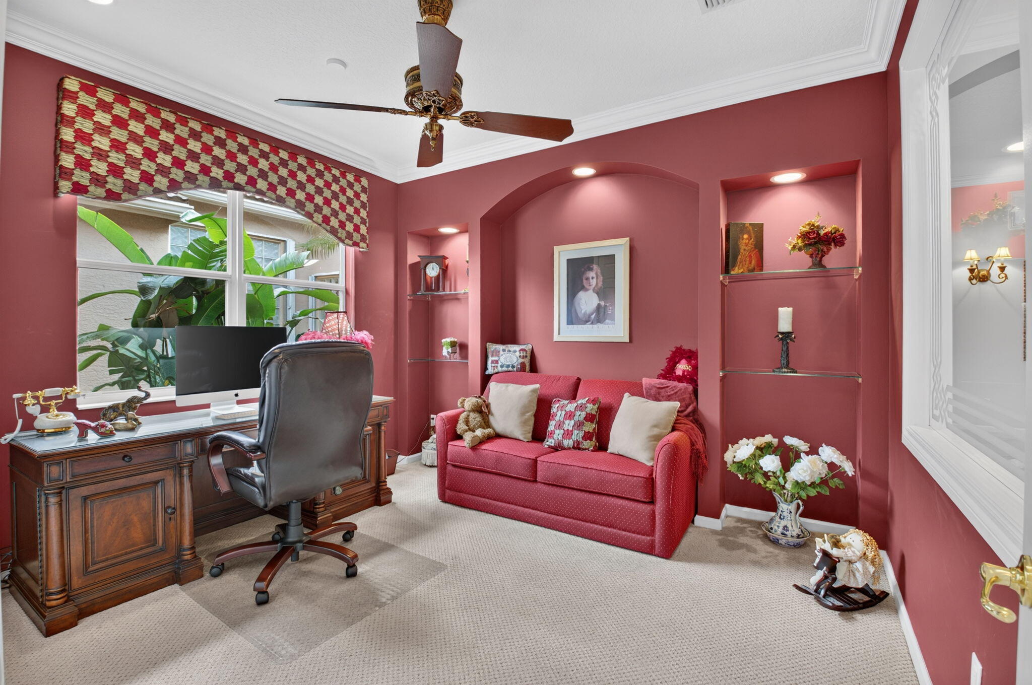 Room featuring dual arched built-in wall niches with recessed lighting and glass shelving, crown molding, and a multi-blade ceiling fan