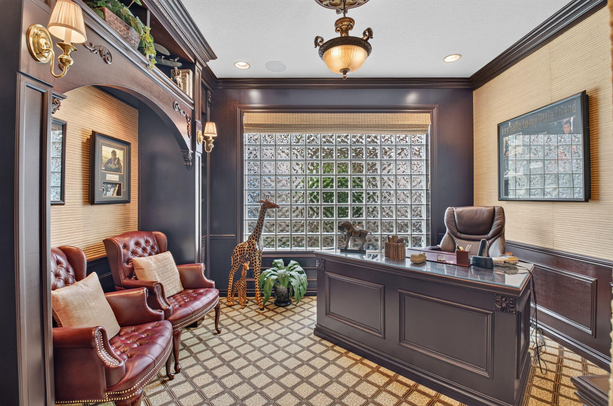Custom wood cabinetry with integrated archway, glass block window feature, textured wall coverings, crown molding, and brass-finish wall sconces