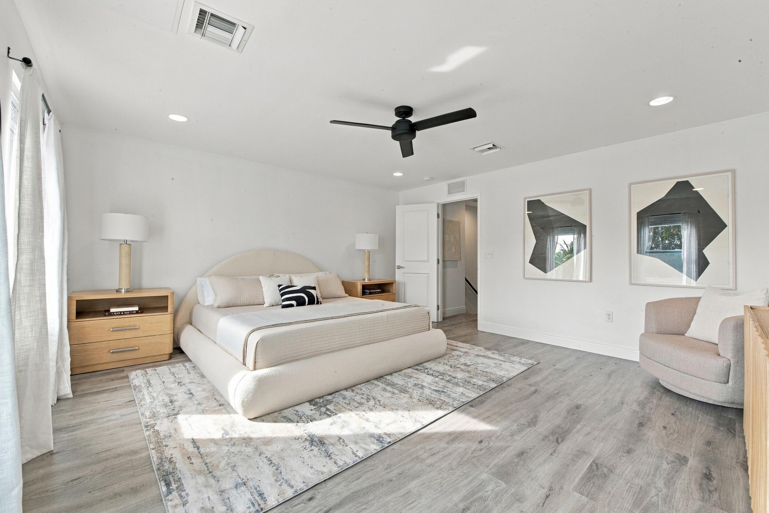 Spacious room featuring light wood-finish flooring, recessed lighting, and a matte black ceiling fan