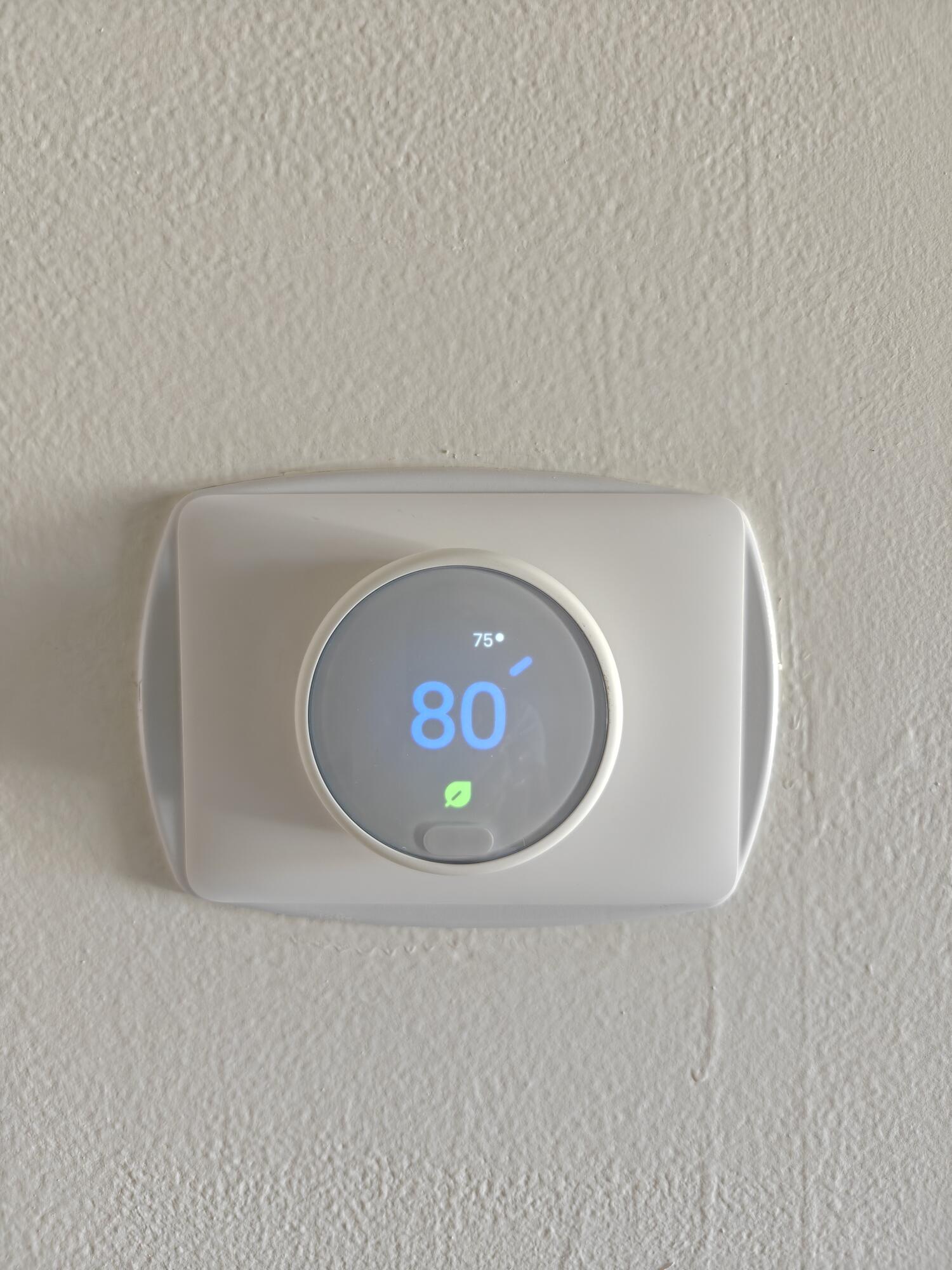 Wall-mounted smart programmable thermostat featuring a digital circular interface