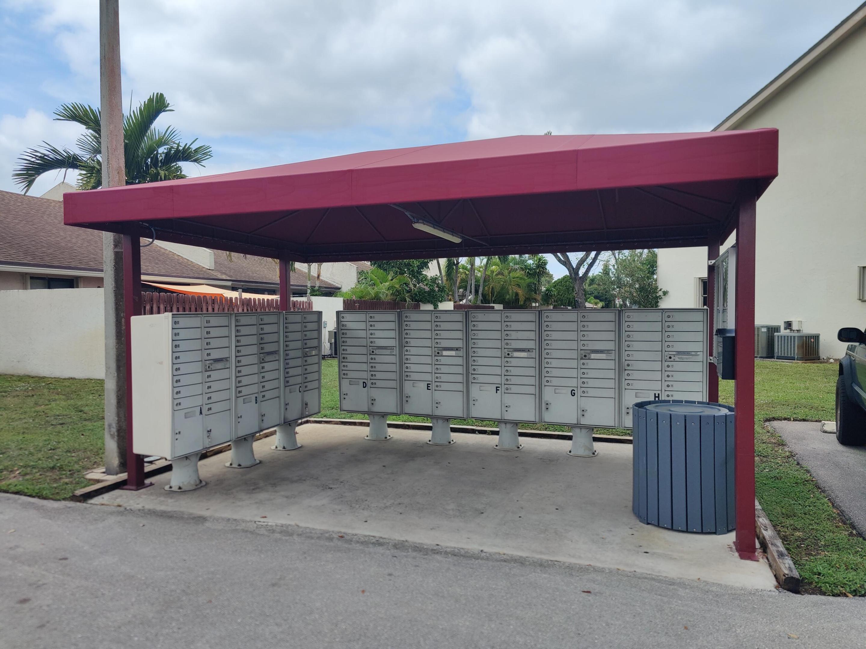 Covered community mail station featuring metal collection boxes and a protective canopy structure