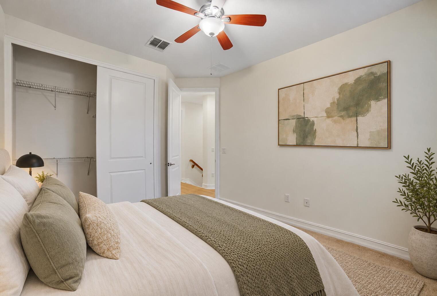 Bedroom featuring neutral wall paint, carpeted flooring, a ceiling fan with light fixture, and a built-in closet with sliding doors