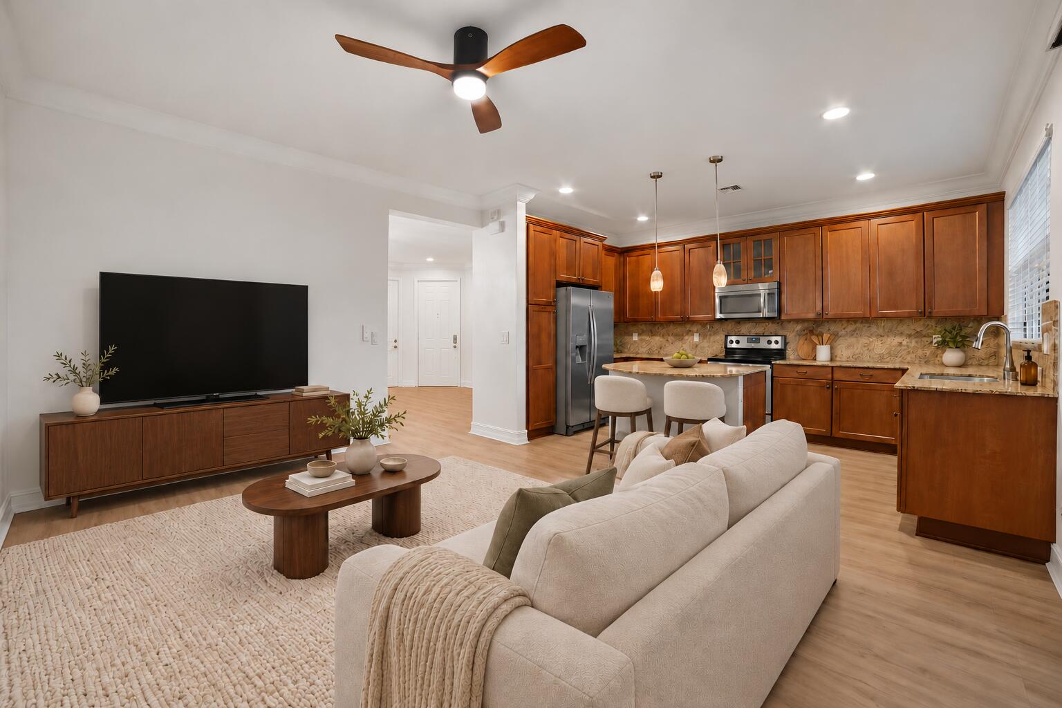 Open-concept area featuring wood-finish flooring, recessed lighting, a modern ceiling fan, wood cabinetry, and stone countertops