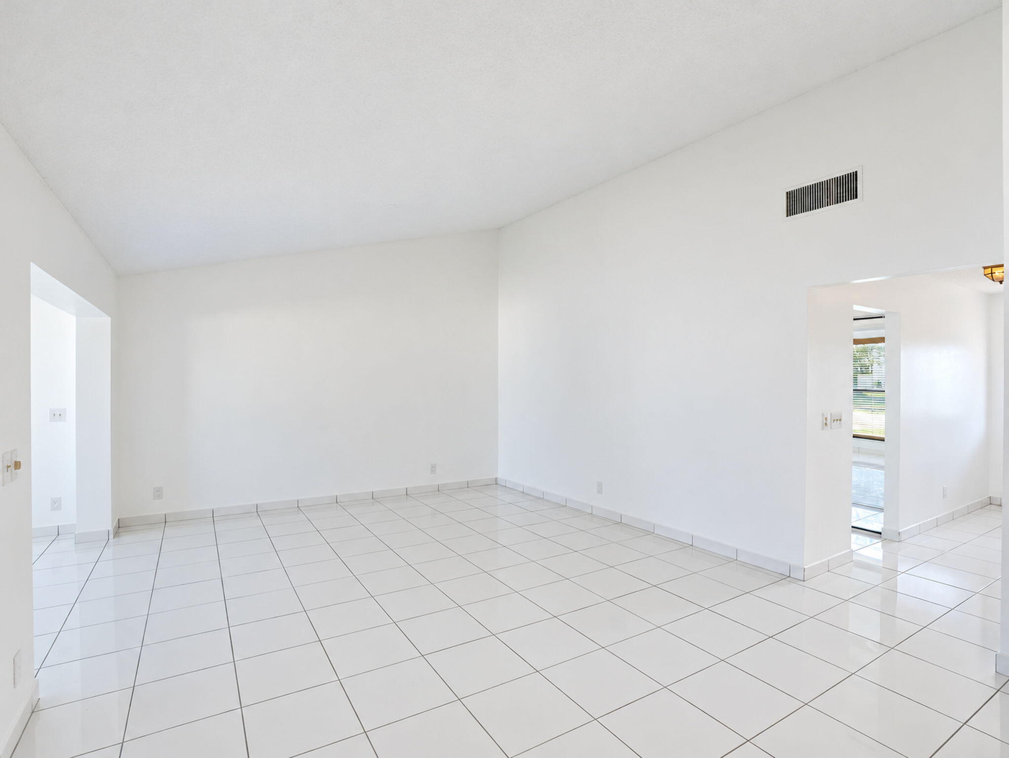 Open floor plan featuring vaulted ceilings and polished ceramic tile flooring