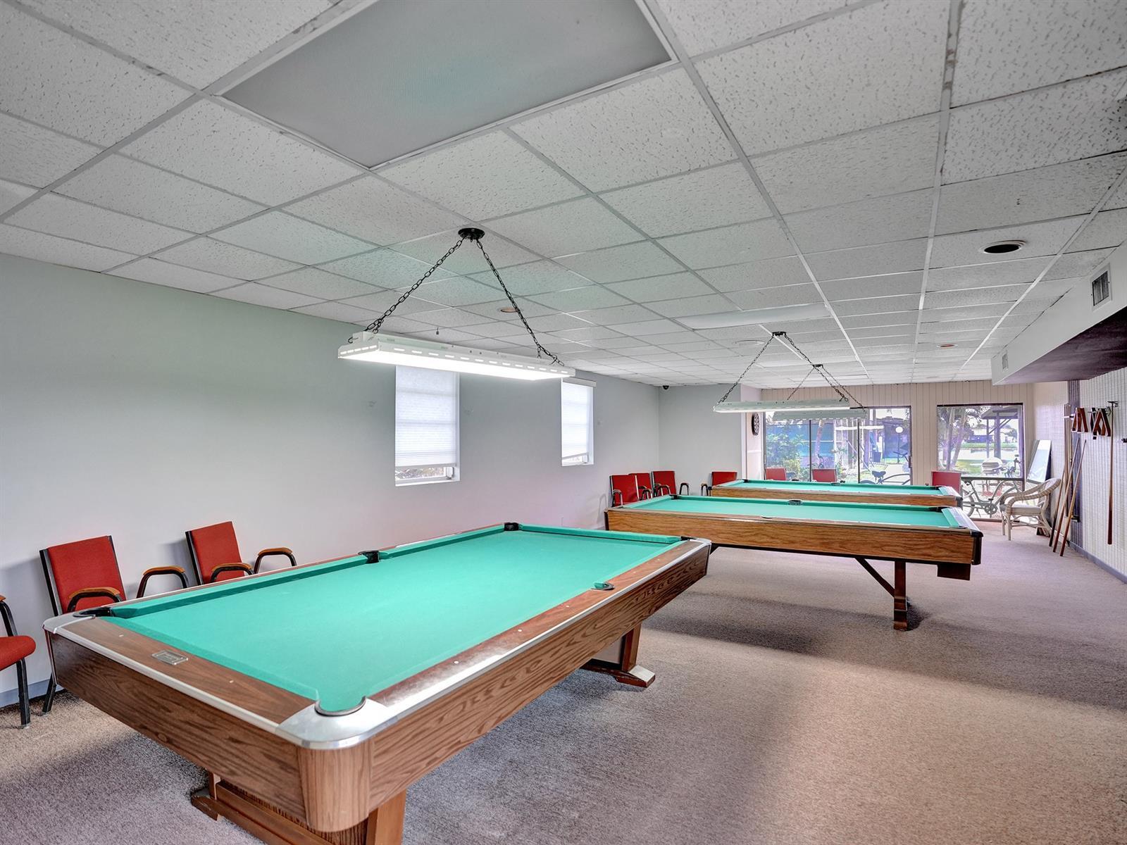 Drop-ceiling room featuring carpeting, recessed lighting, and dual suspended light fixtures