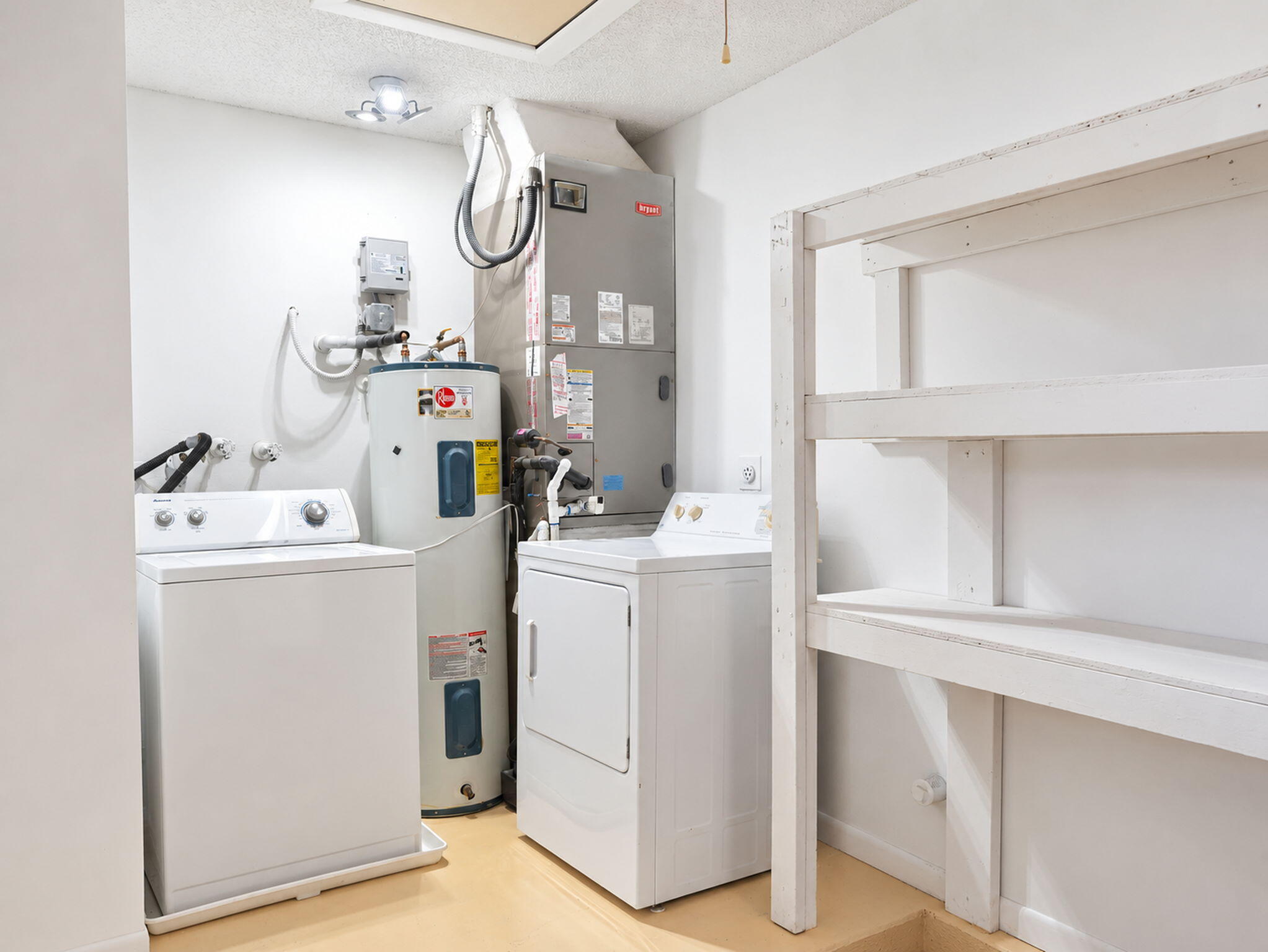 Utility area featuring a water heater, HVAC unit, washer and dryer connections, and built-in shelving
