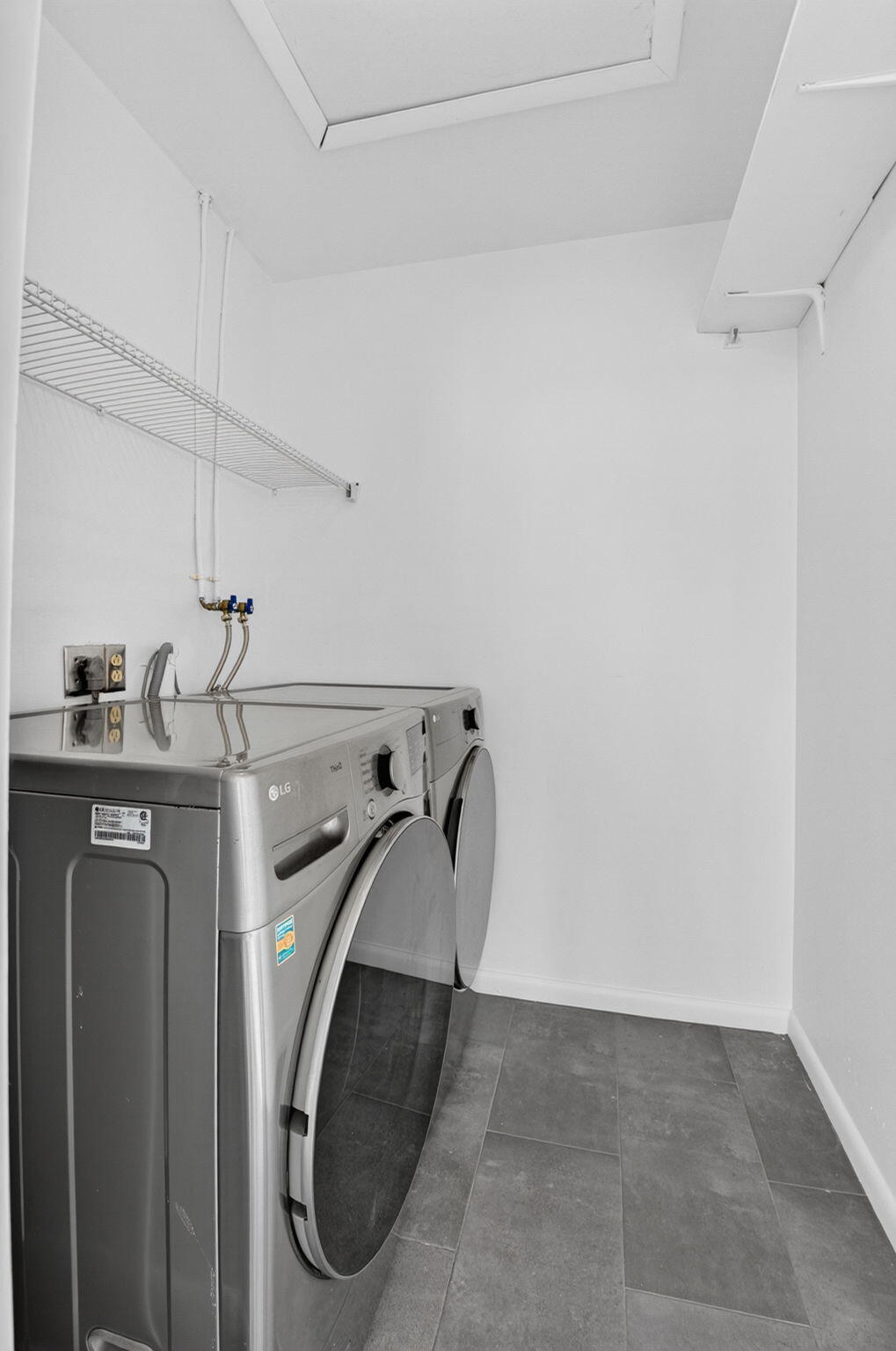 Enclosed laundry room with newer washer and dryer