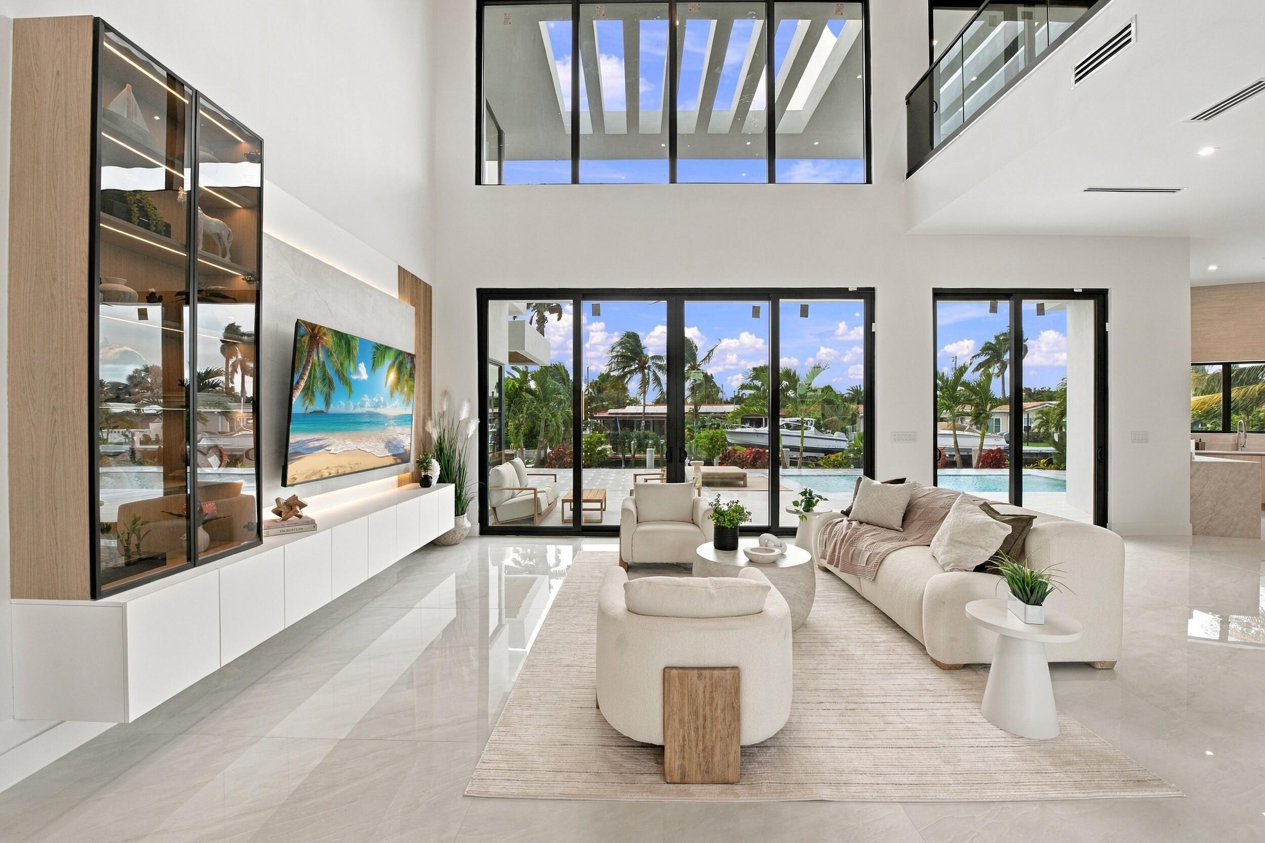 Double-height ceilings, floor-to-ceiling glass panel walls, custom built-in wood-trim cabinetry, stone-finish flooring, and recessed architectural lighting