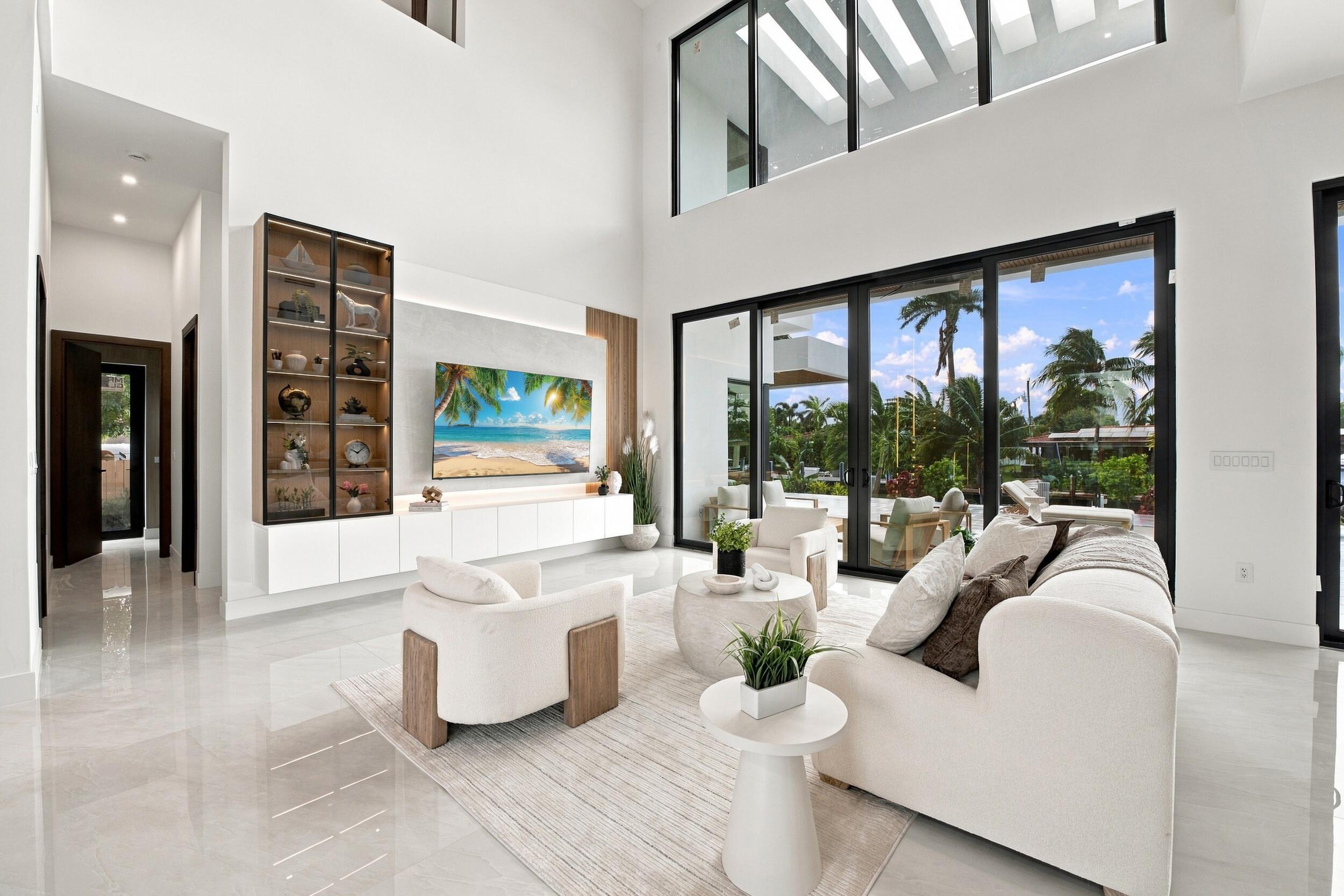 Double-height ceilings, floor-to-ceiling glass wall, built-in floor-to-ceiling cabinetry with integrated display lighting, and polished stone-finish flooring