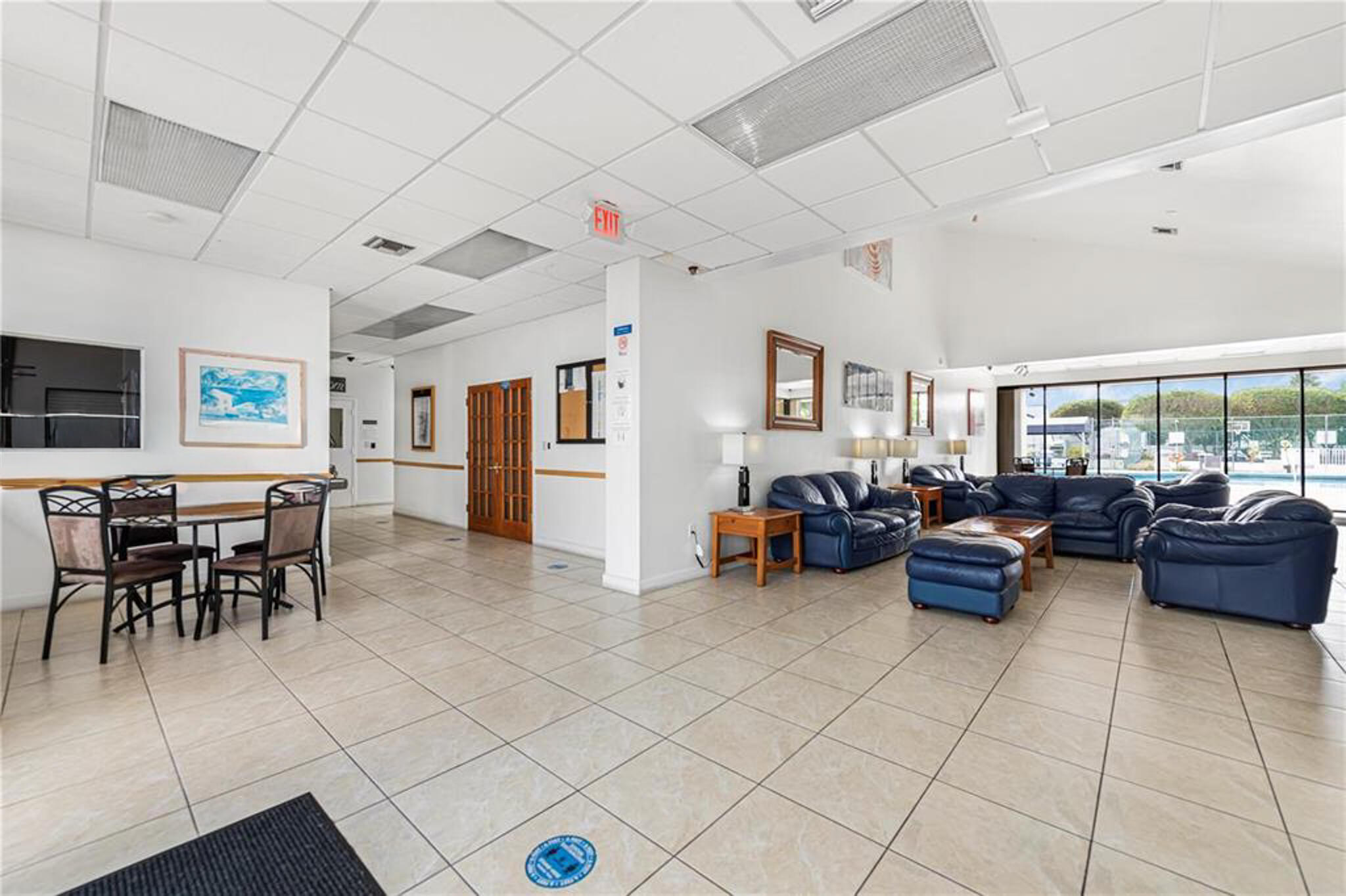 Open floor plan featuring large format tile flooring, vaulted ceilings, and expansive floor-to-ceiling windows