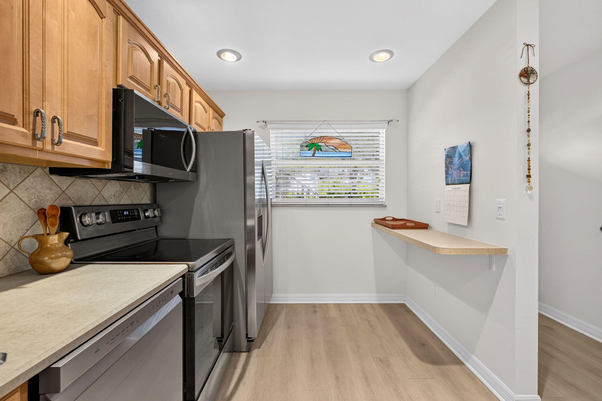 Updated kitchen with warm wood cabinetry and stainless appliances