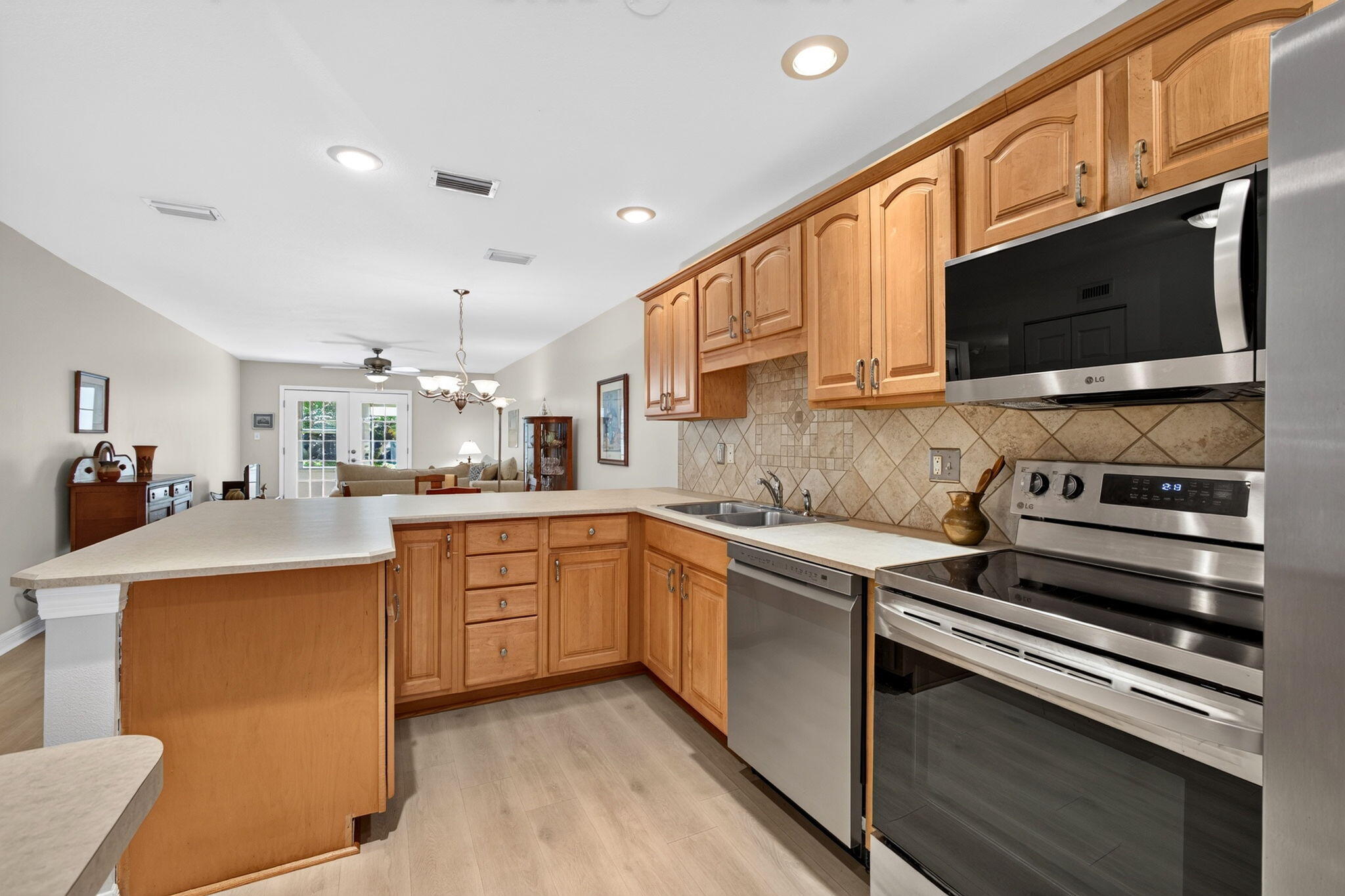 Updated kitchen with warm wood cabinetry and stainless appliances