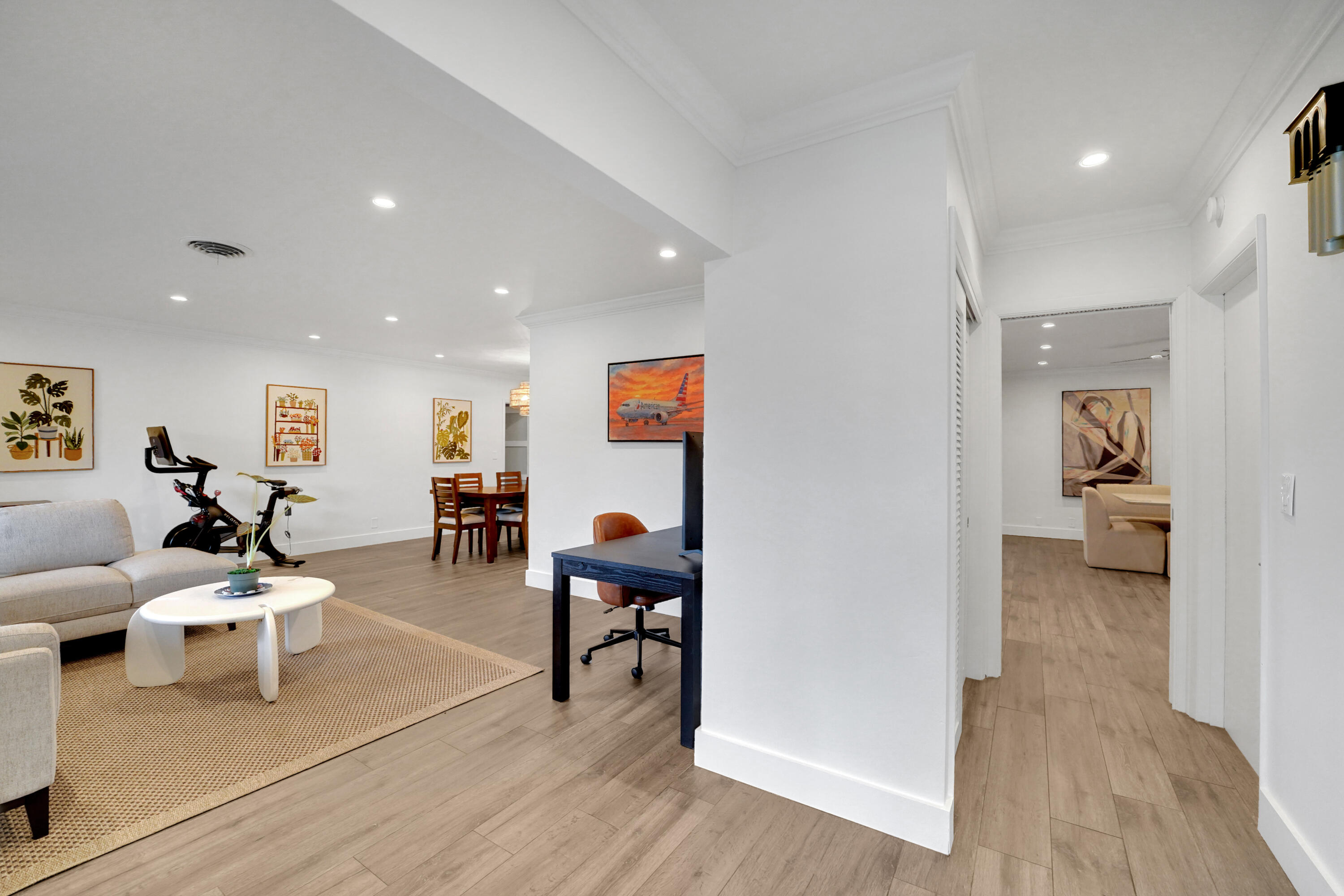 Open-concept interior featuring wood-finish flooring, recessed lighting, and crown molding