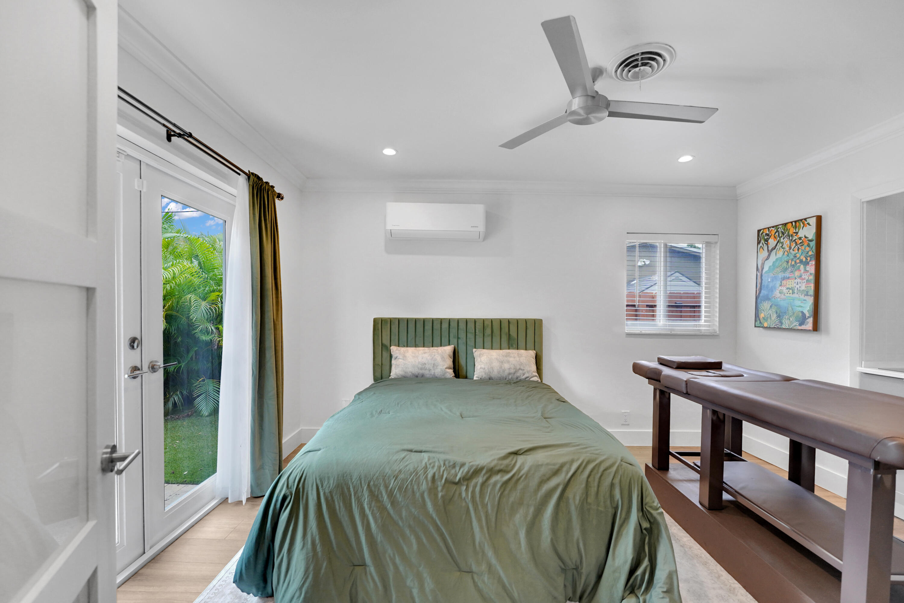 Room featuring wood-finish flooring, recessed lighting, a modern ceiling fan, wall-mounted climate control unit, and glass-paneled exterior doors