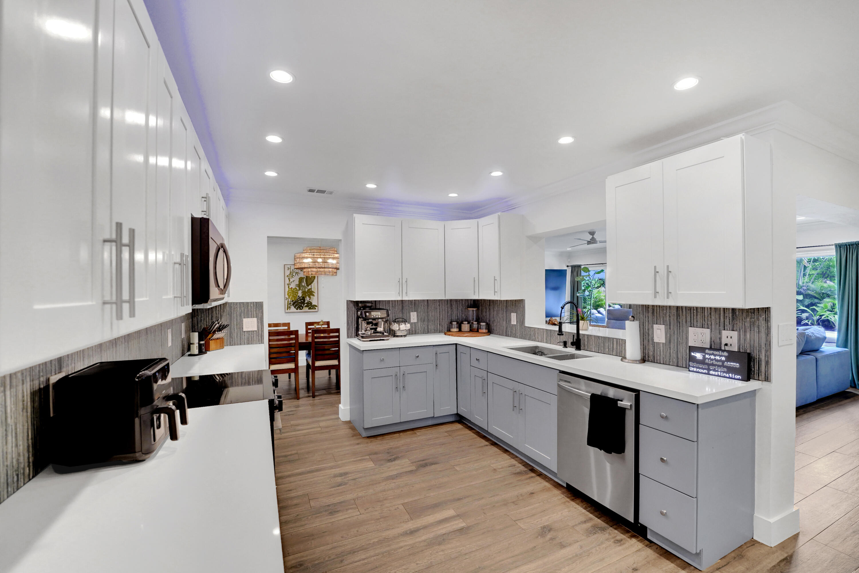 Kitchen featuring white upper cabinetry, grey base cabinetry, white solid-surface countertops, and recessed ceiling lighting