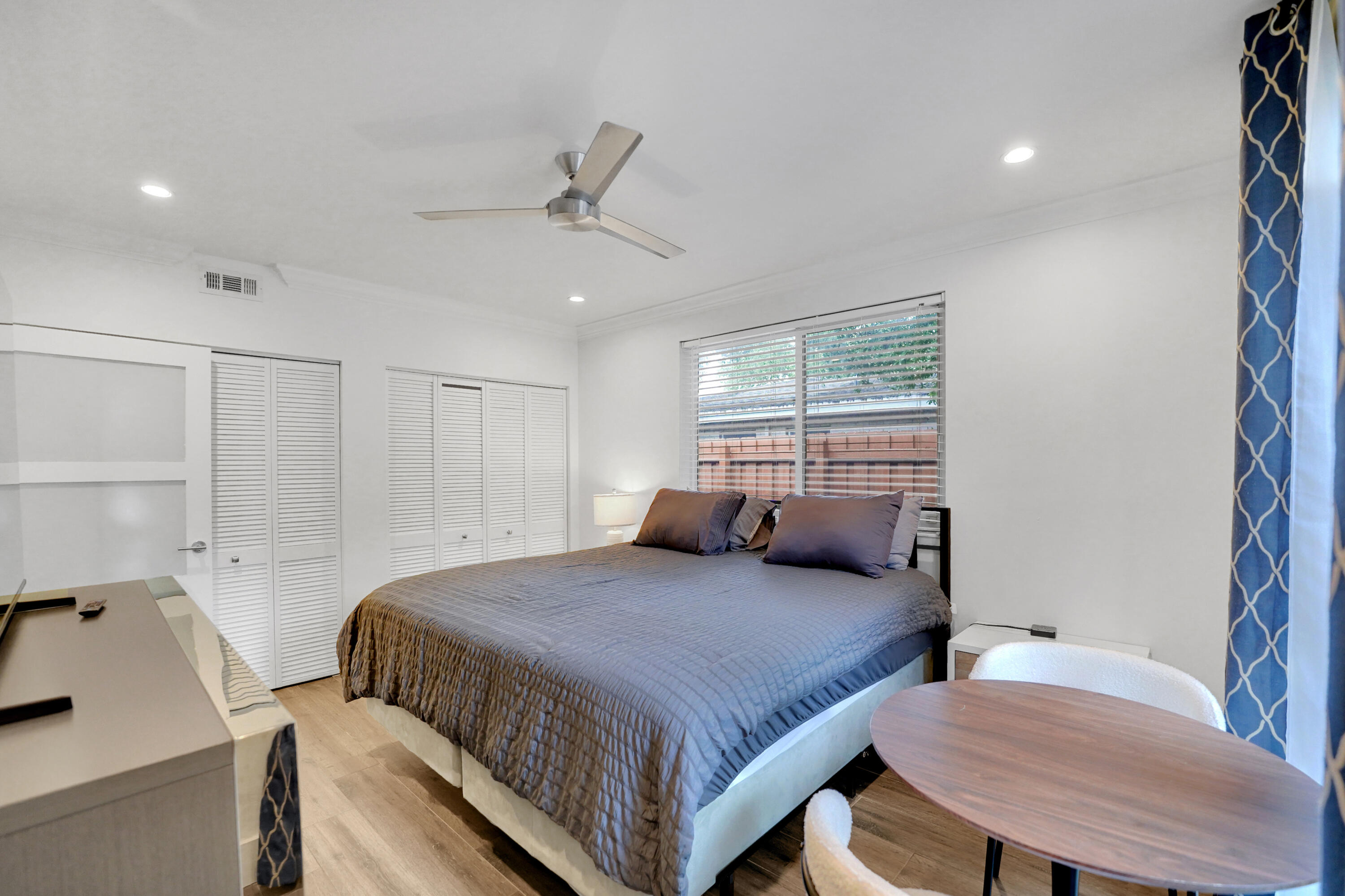 Bedroom featuring wood-finish flooring, recessed lighting, a modern ceiling fan, and louvered-panel closet doors