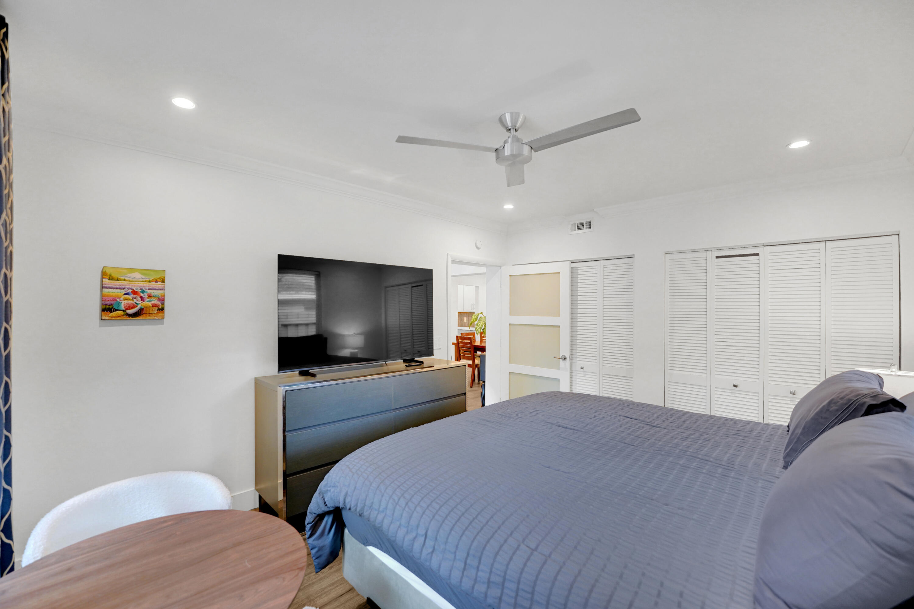 Interior space featuring recessed lighting, a satin-finish metal ceiling fan, louvered closet doors, and a multi-panel door with frosted glass inserts