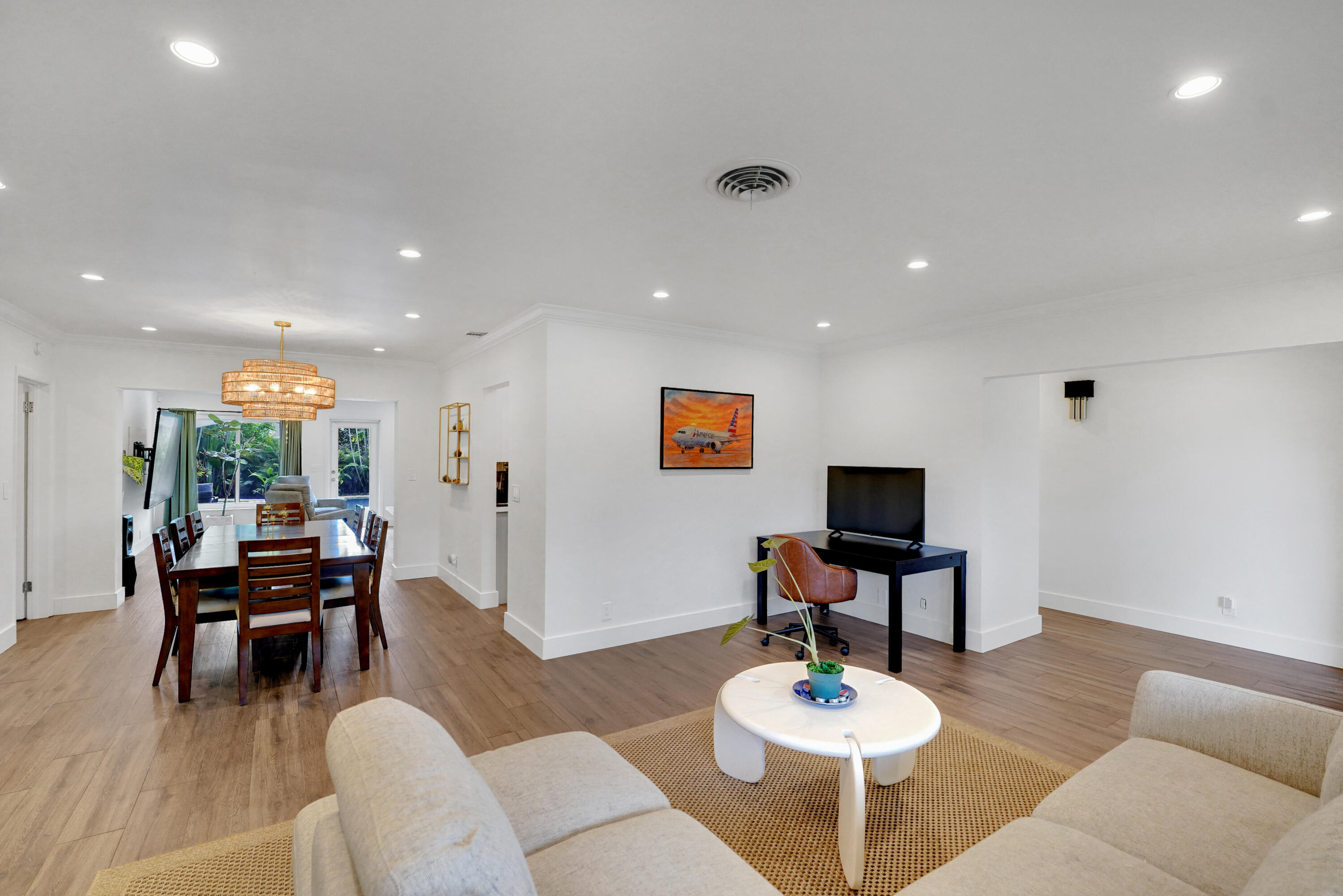 Open interior featuring wood-finish flooring, recessed lighting, and a tiered drum chandelier