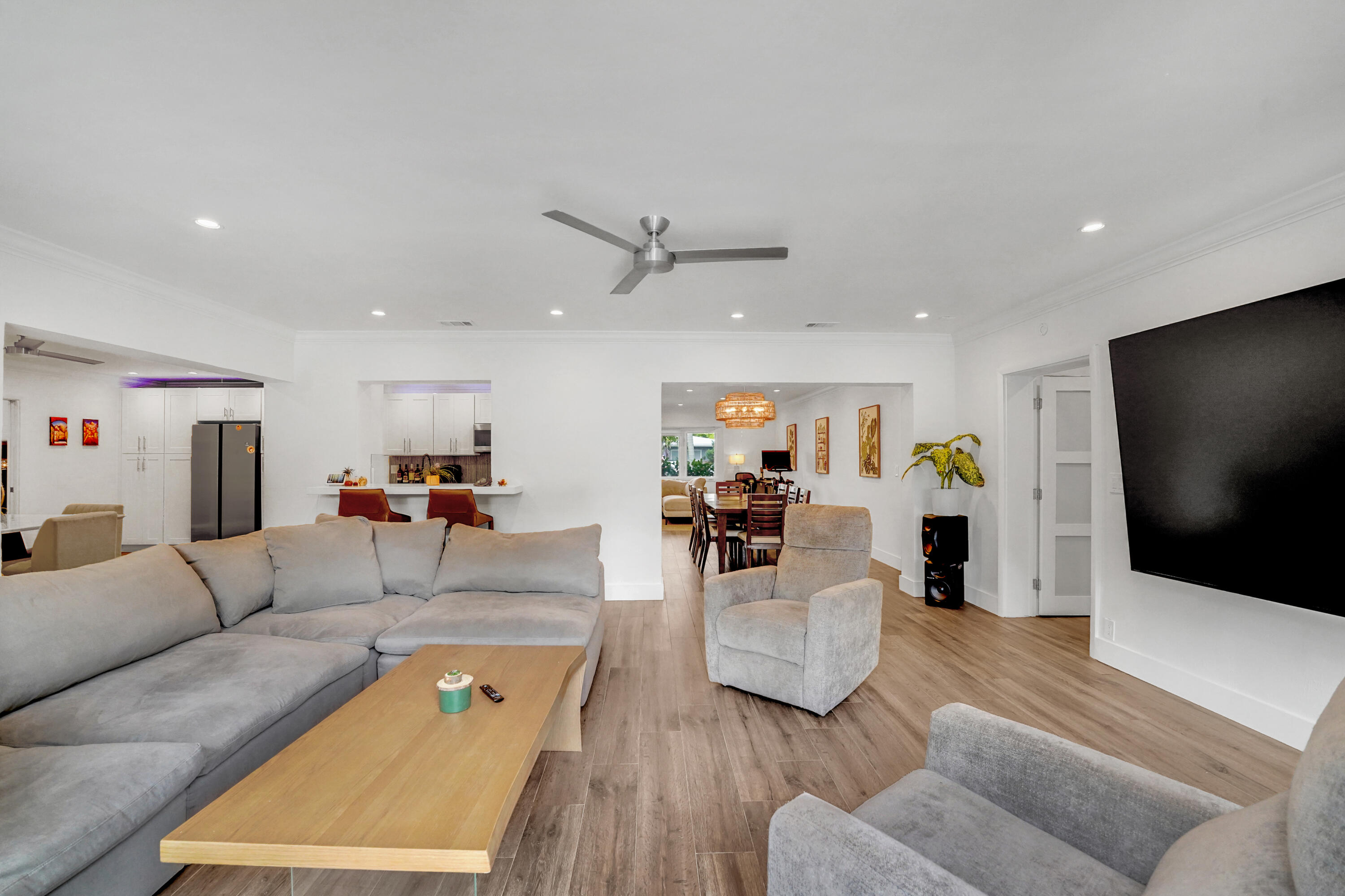 Open-concept interior featuring recessed lighting, crown molding, and a central ceiling fan