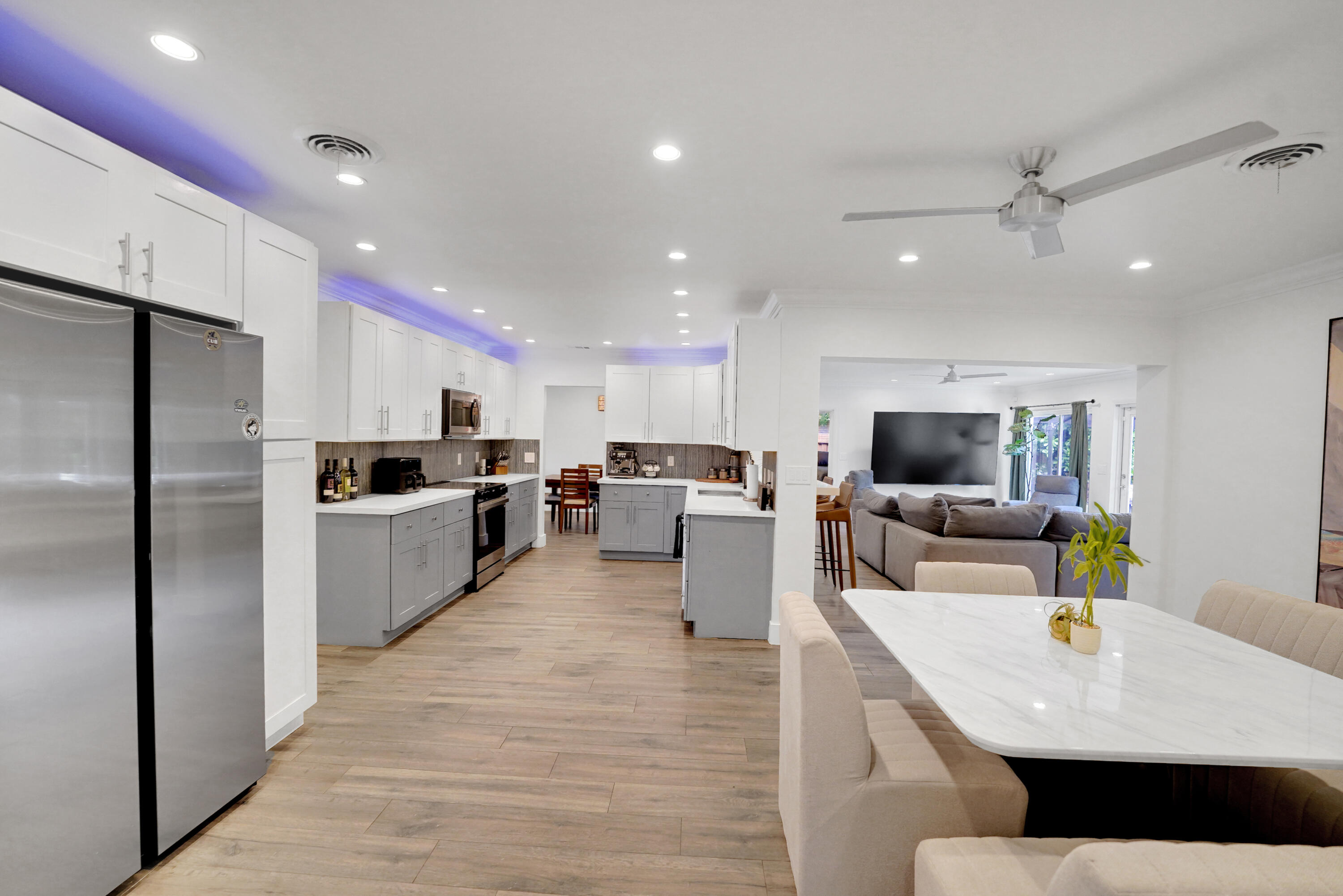 Kitchen featuring two-tone shaker cabinetry, stainless steel appliances, recessed lighting, and cove accent lighting