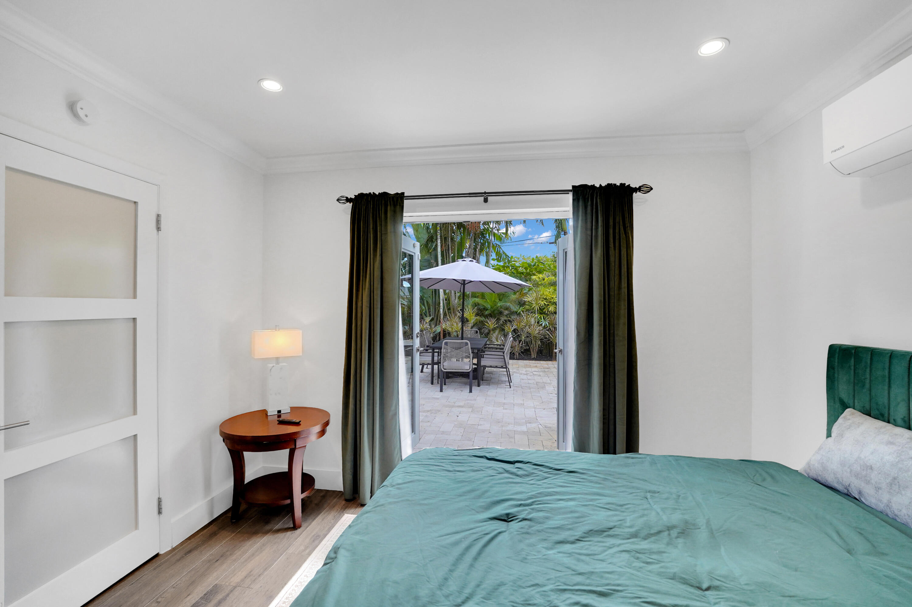 Double French doors with frosted glass accents, recessed lighting, wall-mounted climate control unit.