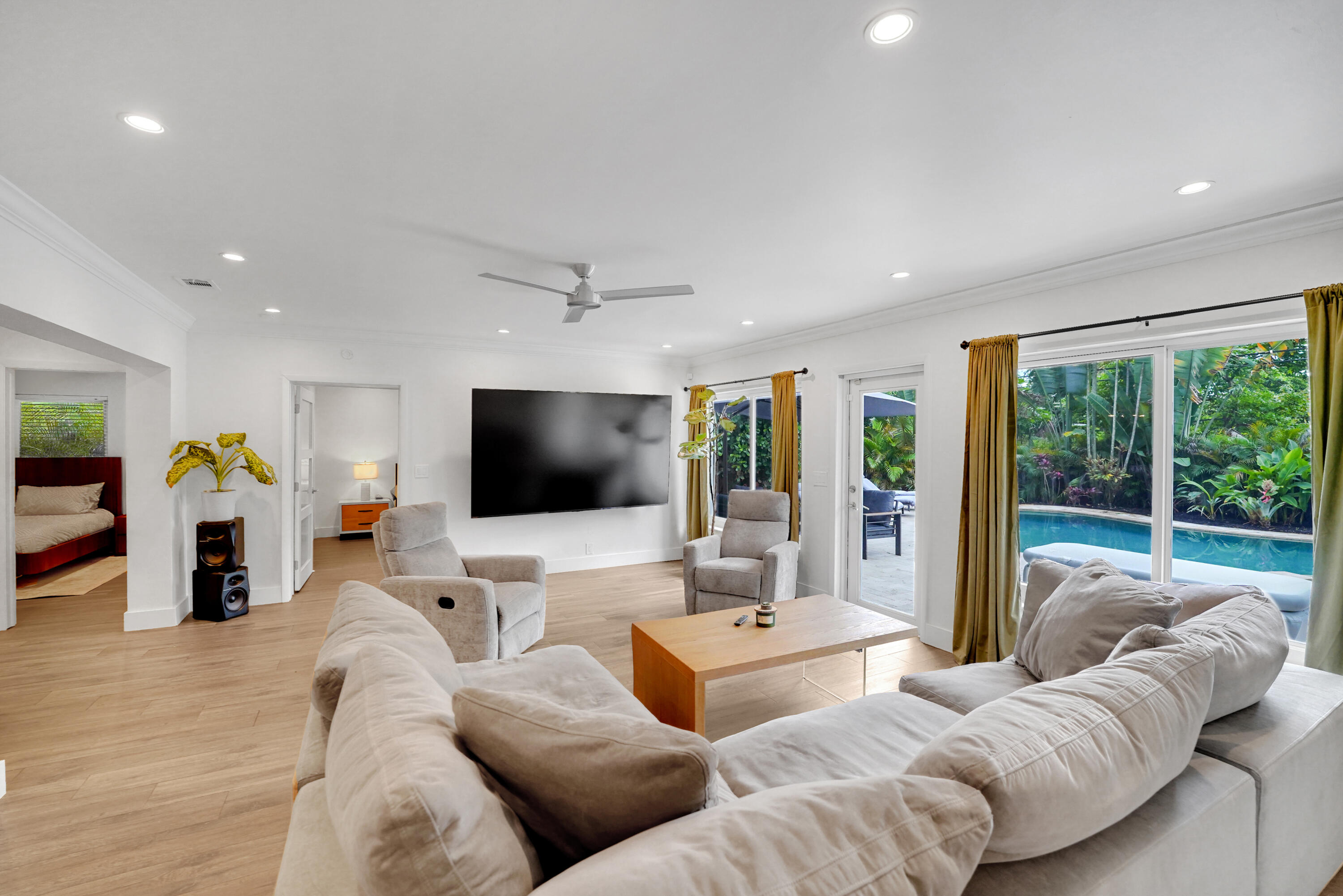 Living area with recessed lighting, crown molding, a ceiling fan, and sliding glass doors providing outdoor access