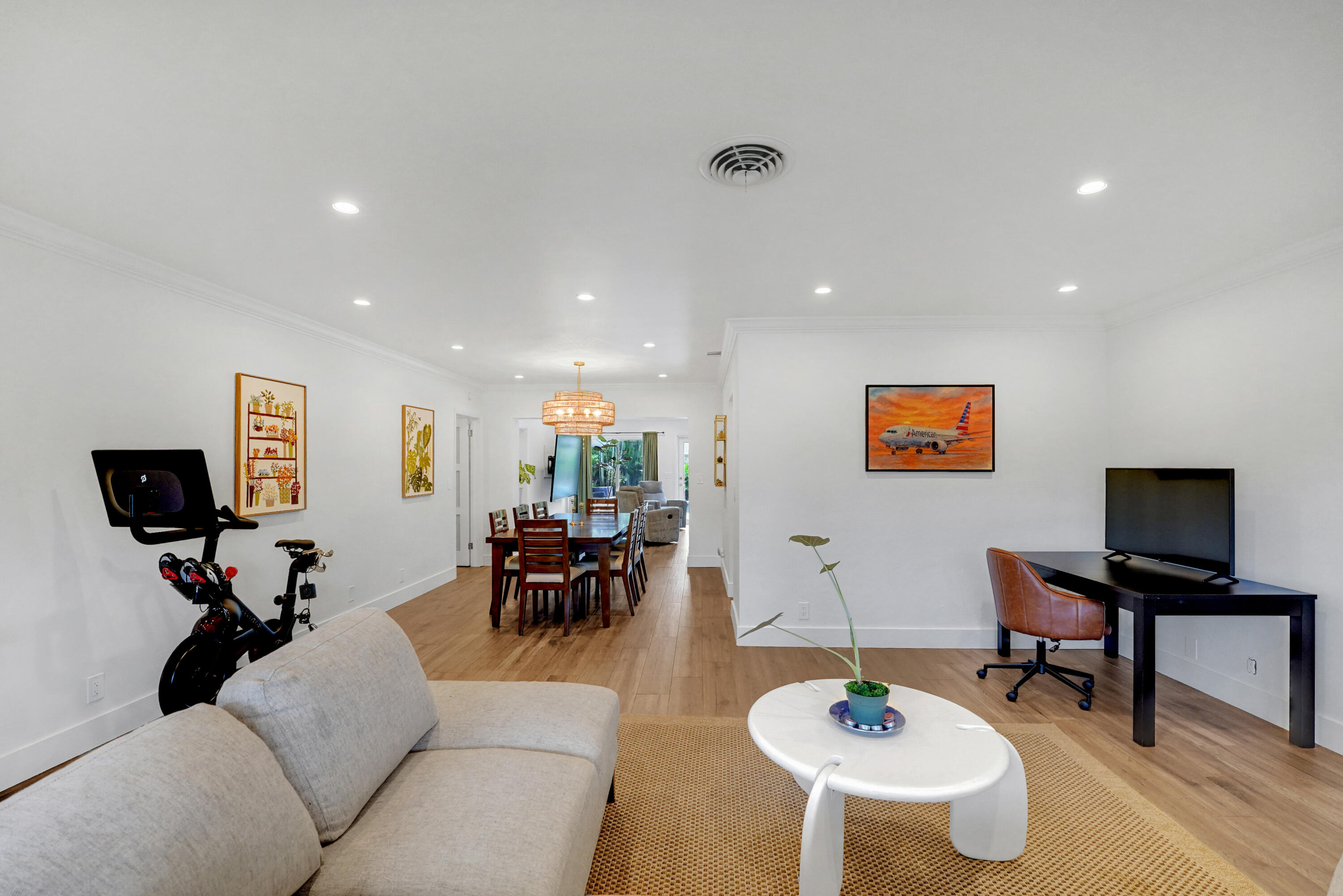 Open-concept interior featuring recessed lighting, wood-finish flooring, and a decorative pendant light fixture