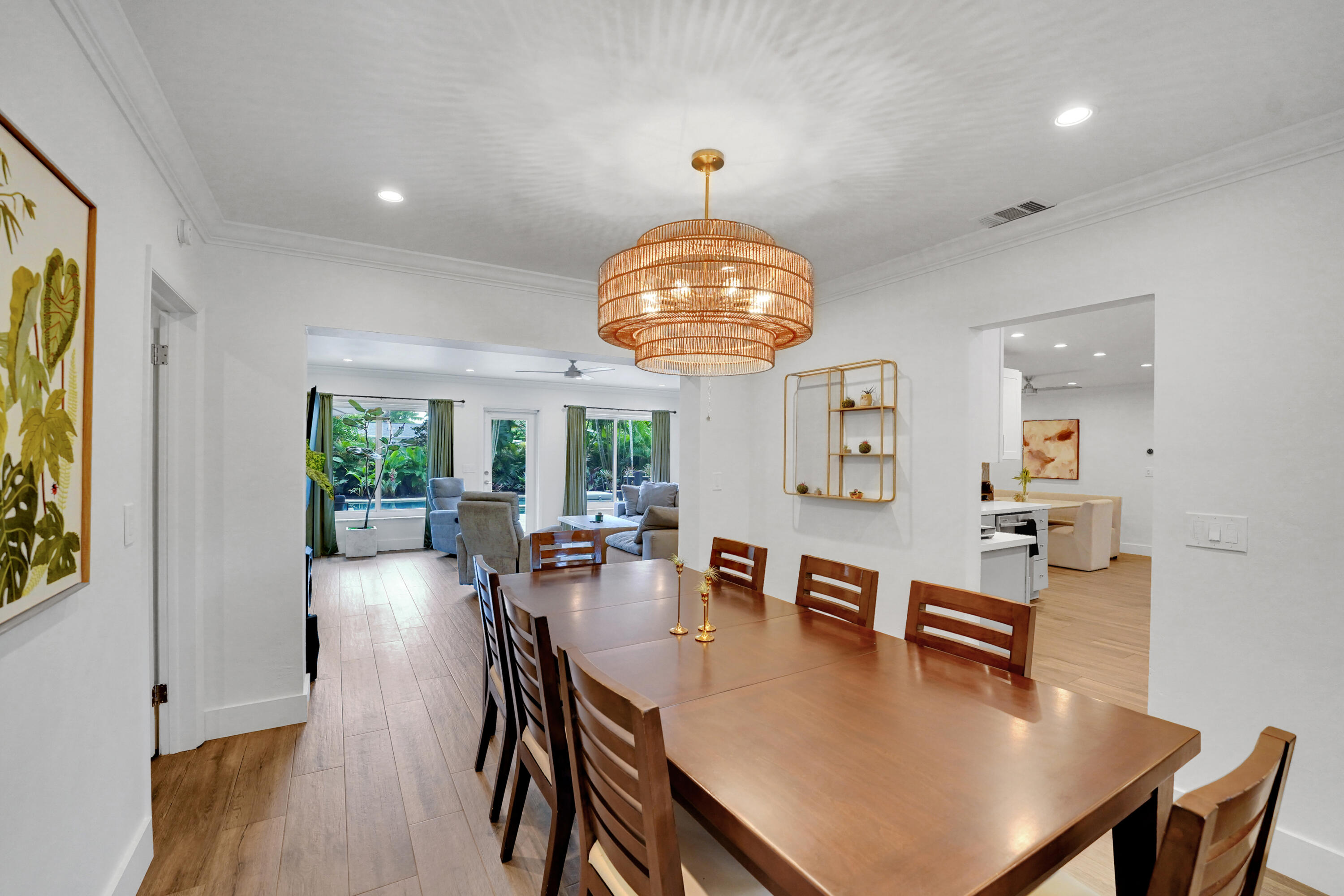 Dining area featuring wood-finish flooring, a tiered woven pendant light fixture, crown molding, and recessed lighting