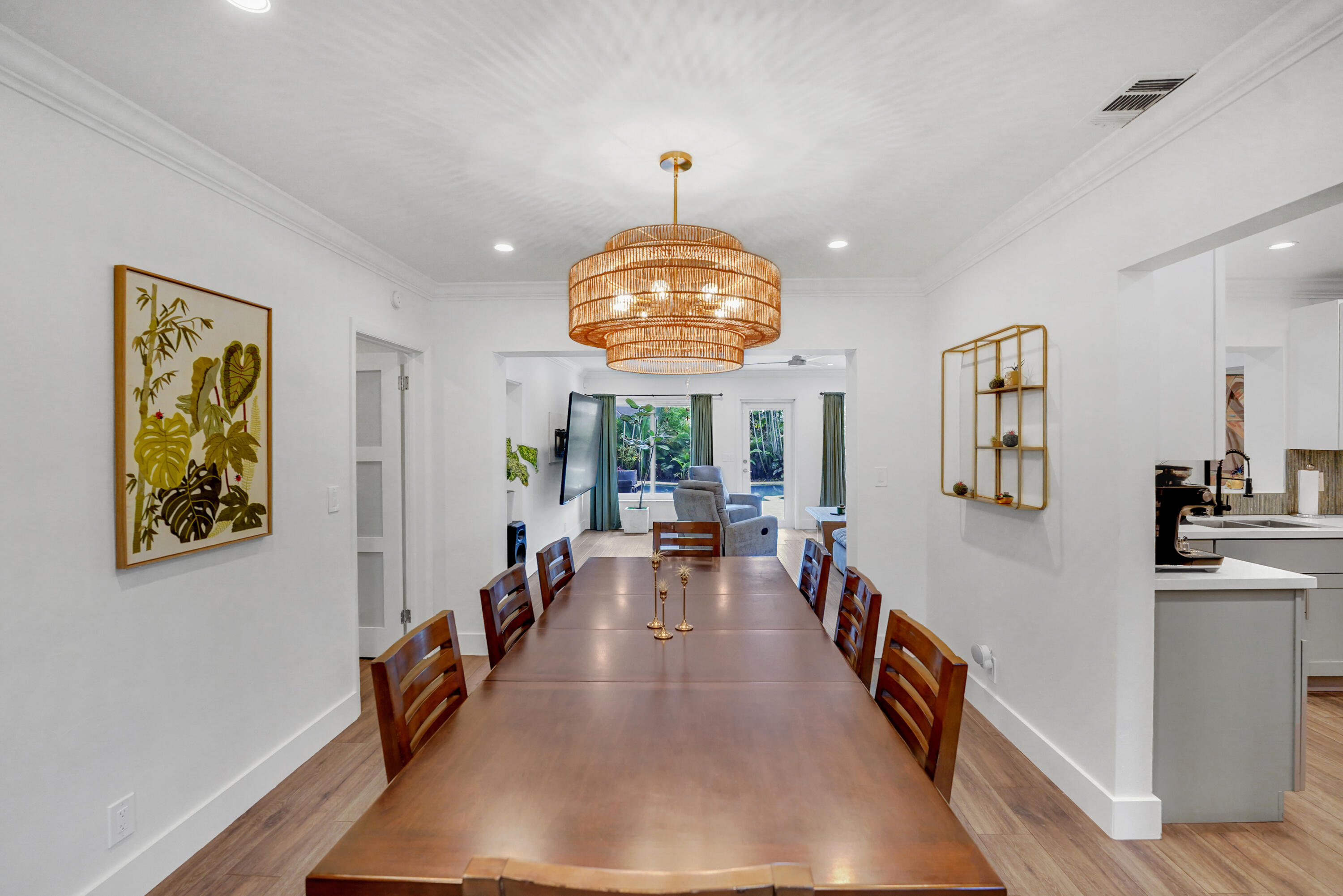 Dining space featuring wood-finish flooring, crown molding, recessed lighting, and a multi-tiered woven pendant fixture