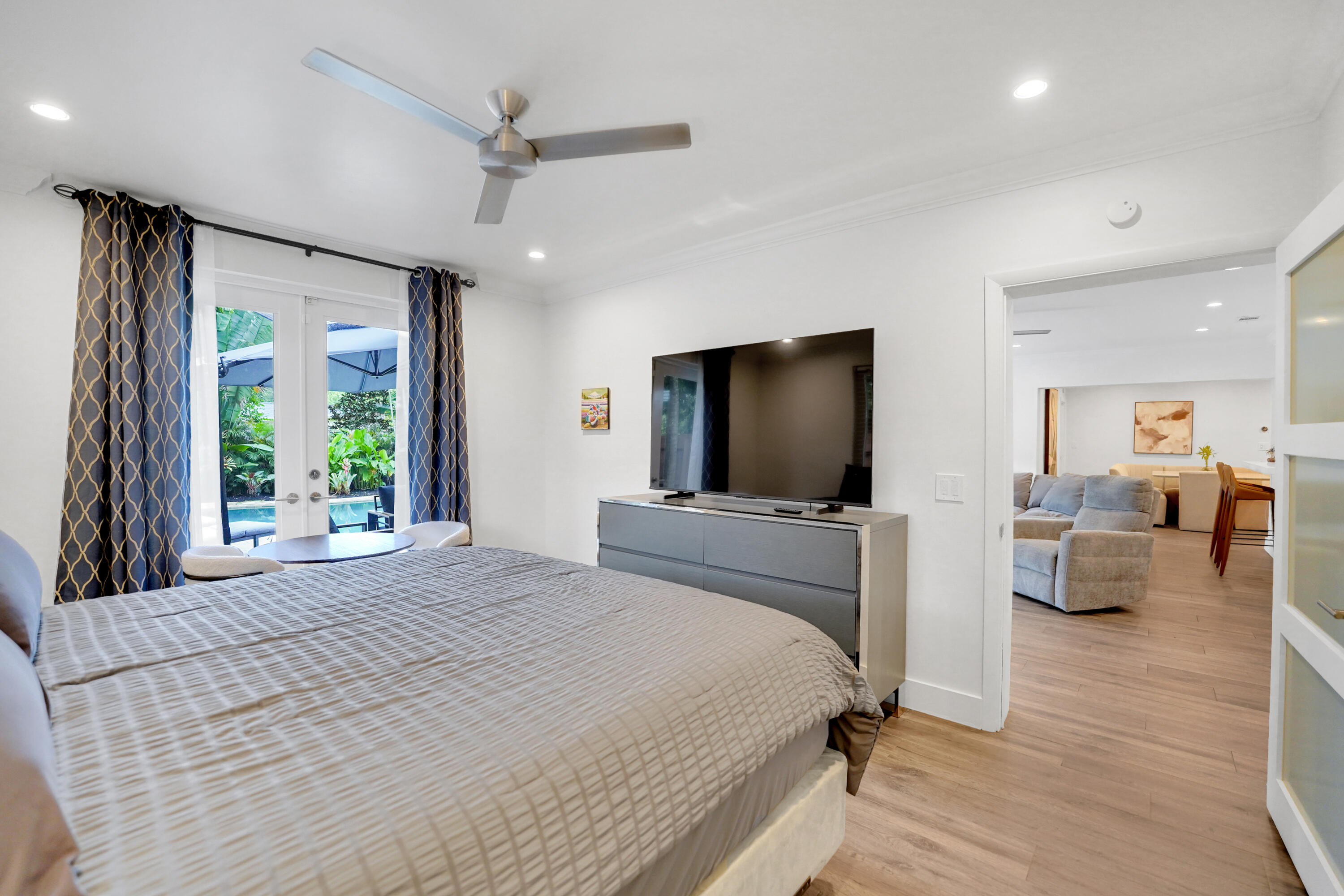 Interior space featuring wood-finish flooring, recessed lighting, crown molding, a ceiling fan, and French doors