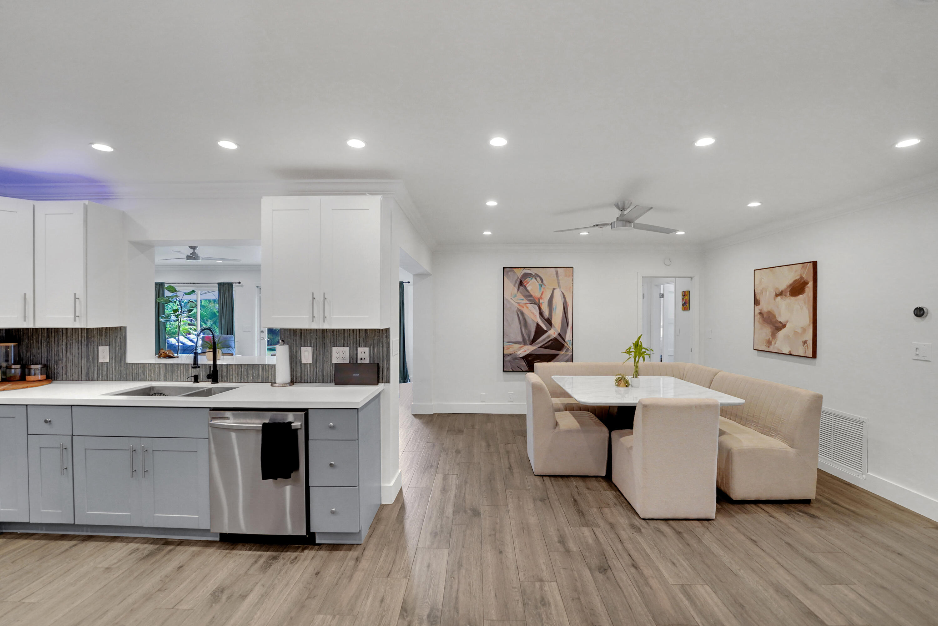 Kitchen featuring two-tone cabinetry, stainless steel dishwasher, recessed lighting, and a neutral tile backsplash