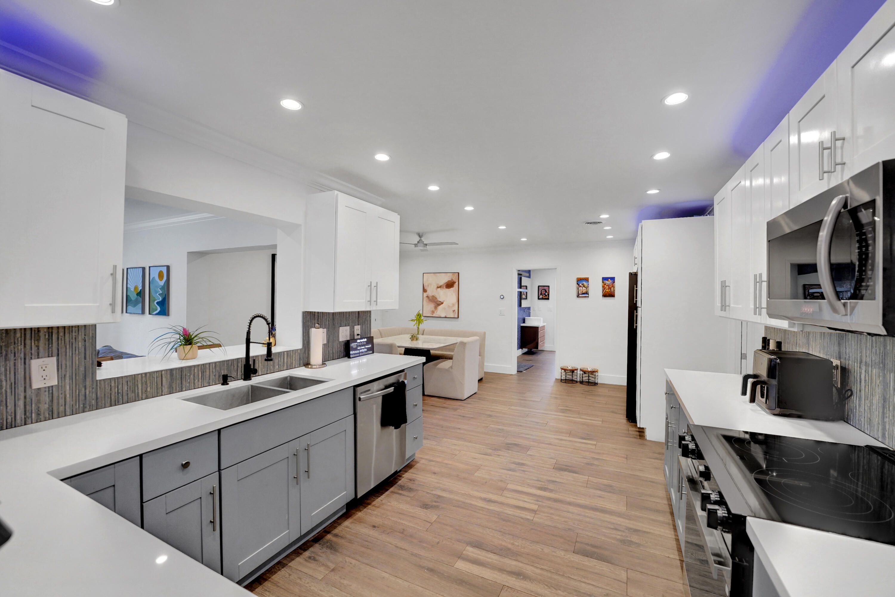 Kitchen featuring white upper cabinetry, grey lower cabinetry, white solid-surface countertops, and recessed lighting
