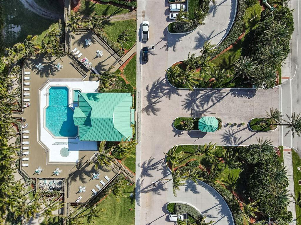 Overhead view showcasing the beautifully landscaped pool area, spacious sun decks, and convenient community parking.