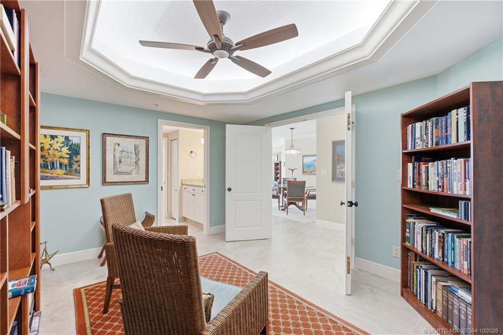 Another view of the library showcasing its custom wood built-ins, Murphy bed, and convenient access to the adjacent bathroom.
