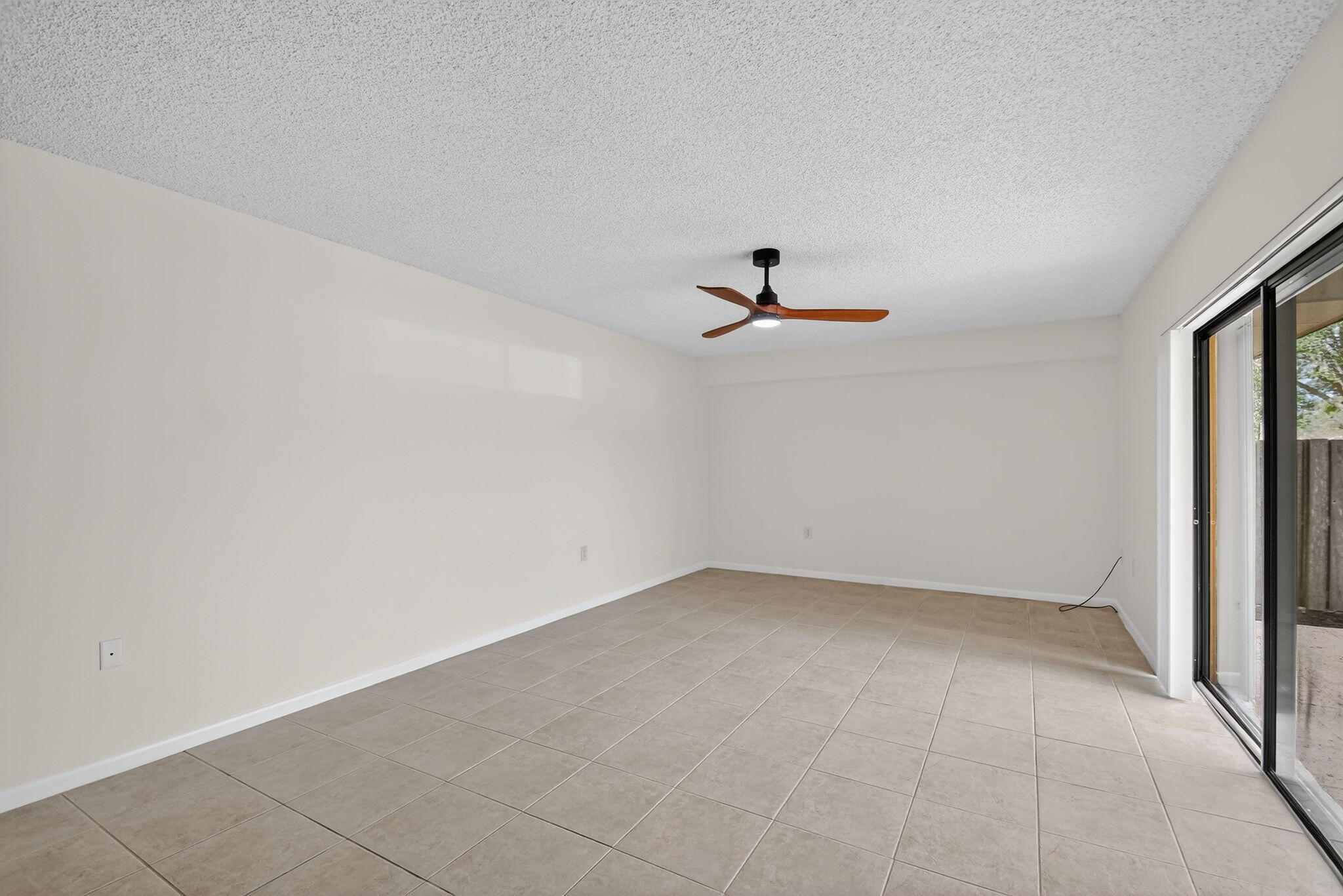 Light and bright living area has sliding glass doors that open to the private and fenced patio